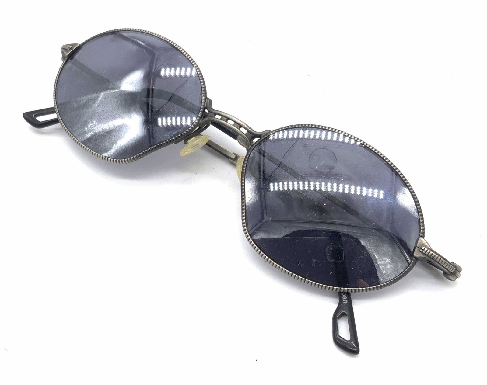 ATS Silver Toned Metal Framed Sunglasses: A pair of ATS sunglasses. Black hued lenses with a silver tone metal frame. Interior reads: ATS, 09. Piece possesses some wear consistent with use, frames have a bend to them. Approx. 1.5L x 5W in. At