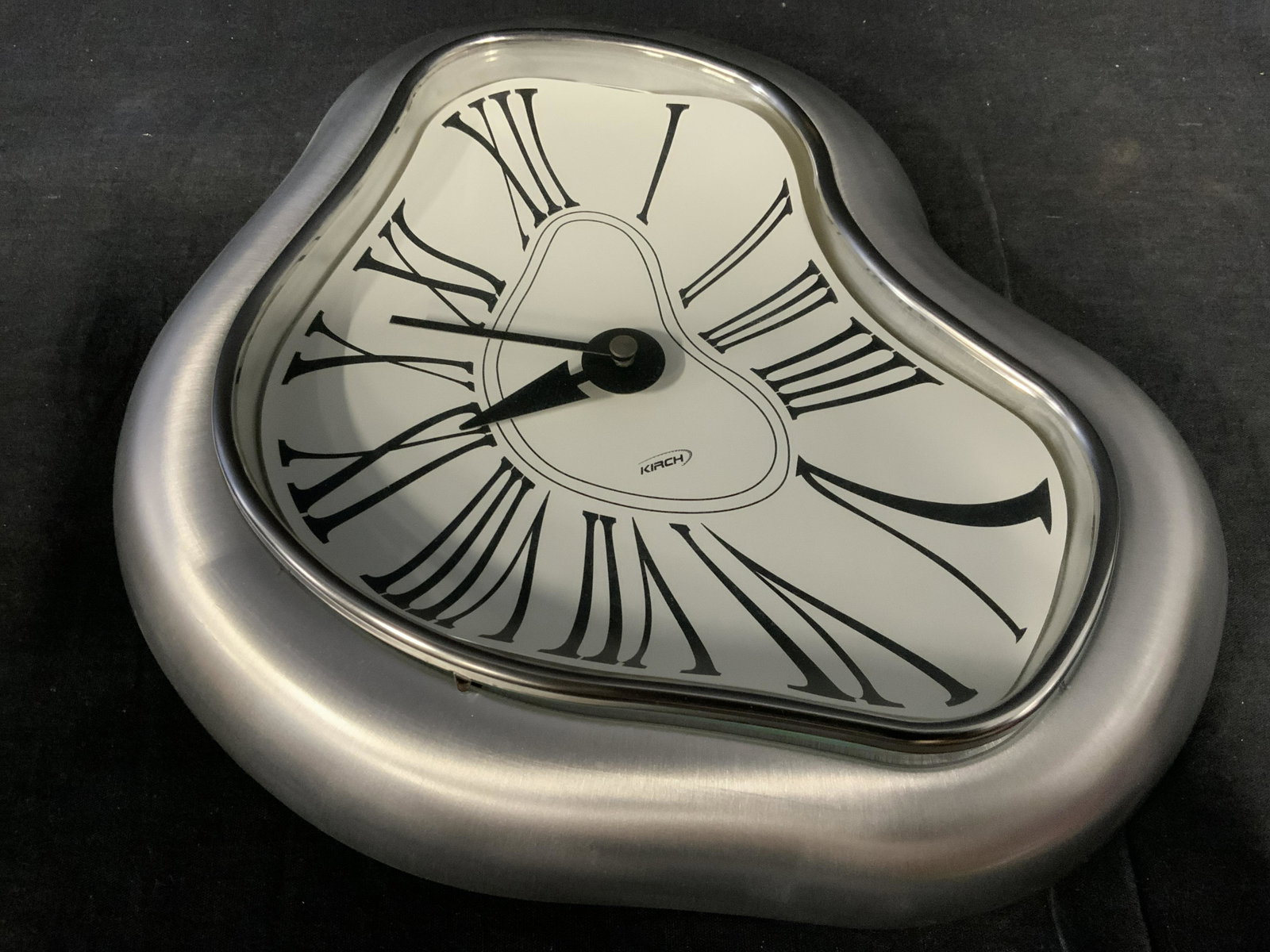 KIRCH Melting Wall Clock: KIRCH melting wall clock, label to the surface reads ‘Kirch’, clock made to appear as if it’s melting, label to reverse reads ‘Kirch industrial co. Warranty void if removed’, clock is batter