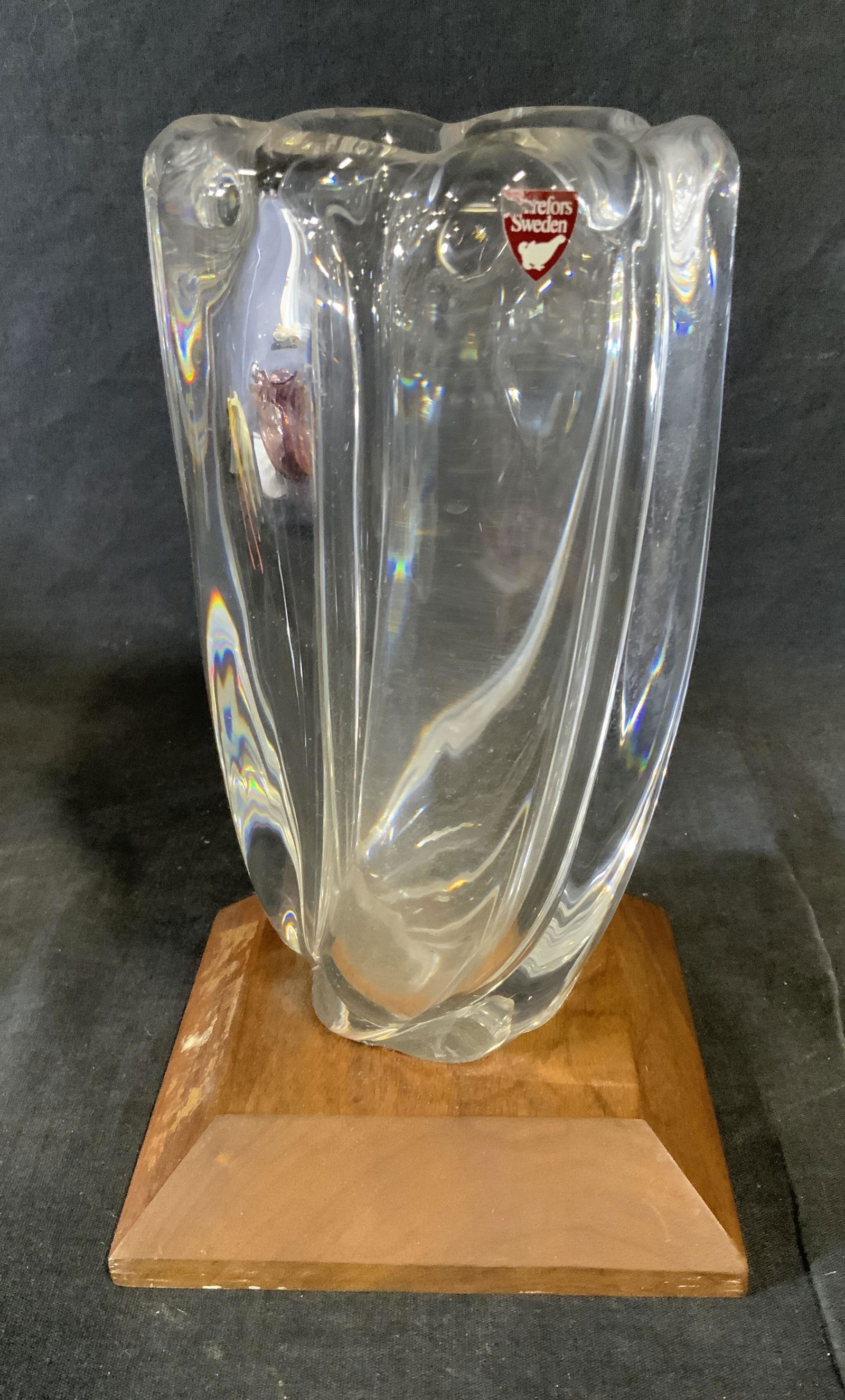 ORREFORS SWEDEN Crystal Vase with Wooden Base: Orrefors Sweden crystal vase with wooden base, label to vase partly ripped text reads ‘Orrefors Sweden’, subecjt a twisting crystal vase attached to a wooden block base, surface wear and chips to