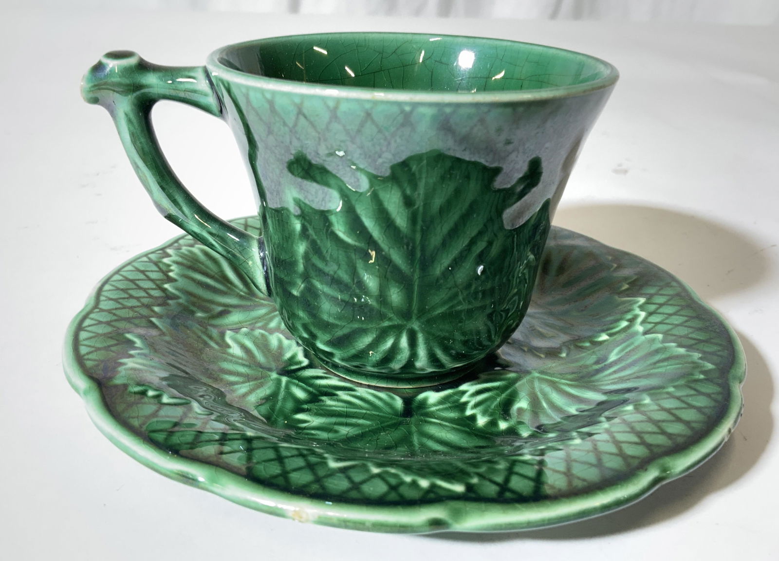 Lot 4 GIEN FRANCE Teacup & Saucers: Underside of each piece are marked GIEN FRANCE. Lot includes 2 teacups and 2 saucers. Each piece is green toned with leaf and diamond shaped detail. Saucers measure approx 5 inches wide. Porcelainware