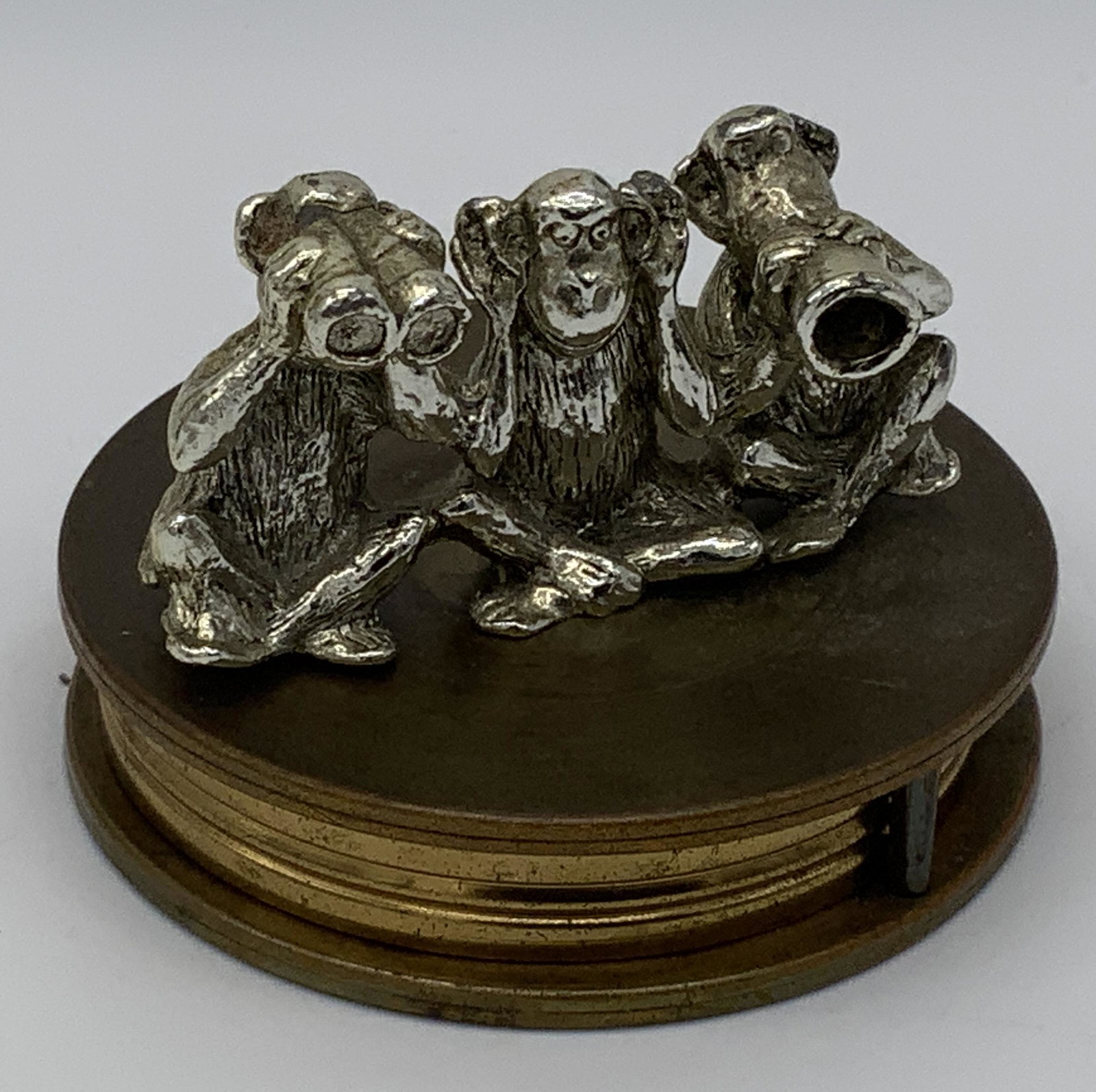 Desk Top Magnifying Glass: Desk top magnifying glass, no apparent inscriptions or markings, subject a pull out magnifying glass with a figural piece to the top of the cover, figural depicts three monkeys pantomiming hear no evi