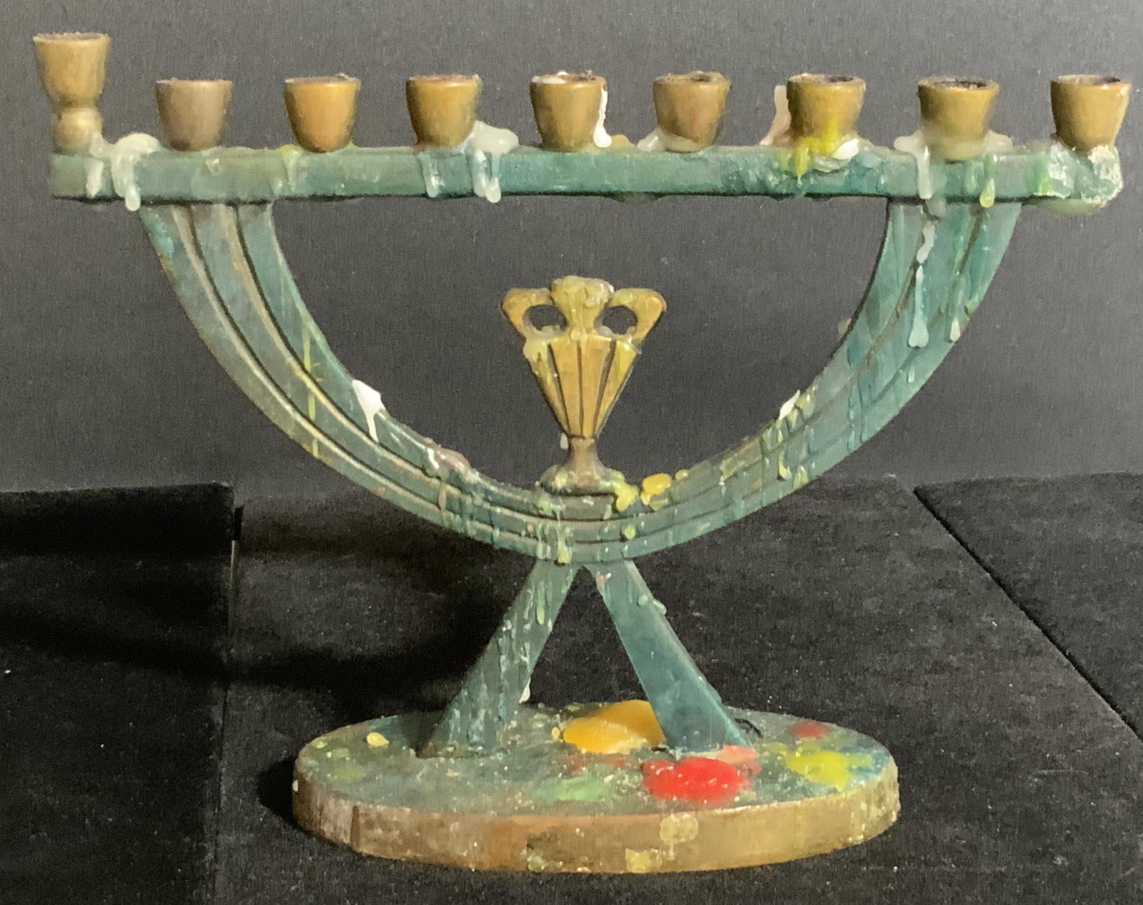 Collectible Israeli Metal Menorah, Judaica: A metal menorah crafted in Israel. Appears to be crafted from brass. Underside reads Made In Israel. Piece has wear consistent with use. Candle wax residue is present. 6H x 7W in. Judaica, hebraica, J