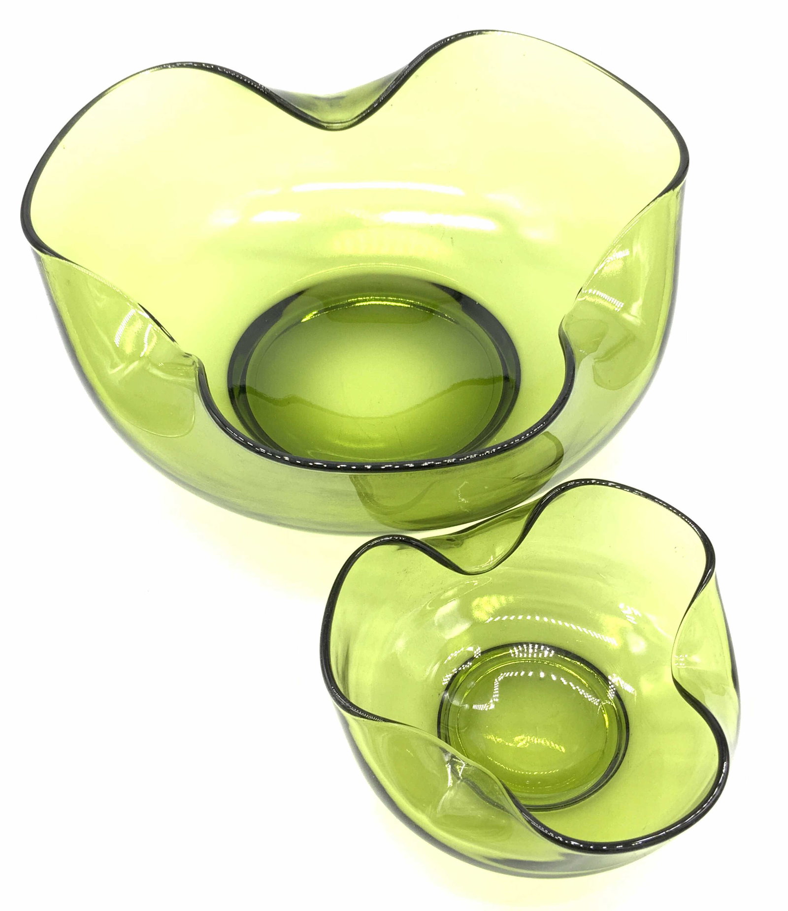Pair Green Art Glass Pinch Bowls: A pair of green hued art glass pinch bowls. Pieces feature unique pinched rims. One is larger than the other. Larger piece measures approx. 4H x 9W in. Pinch bowl, bowls, kitchenware, green Art glass,