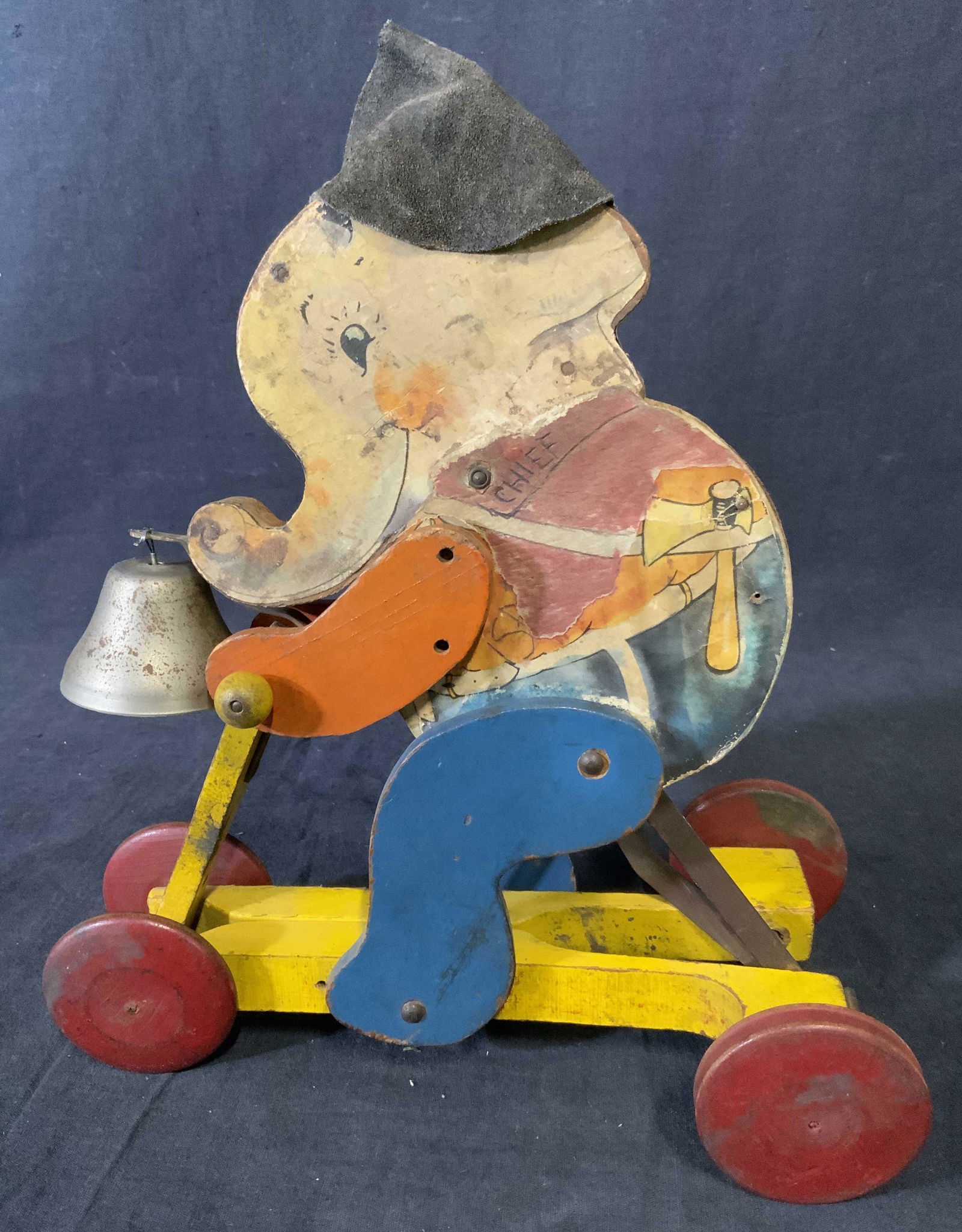 Vintage #110 FISHER PRICE FIRE CHIEF ELEPHANT: Vintage 1932 Chubby Chief, a round and happy elephant firefighter. Chief rides a wooden scooter clanking his bell, pumping his legs, and moving his head and trunk up and down when pushed or pulled. El