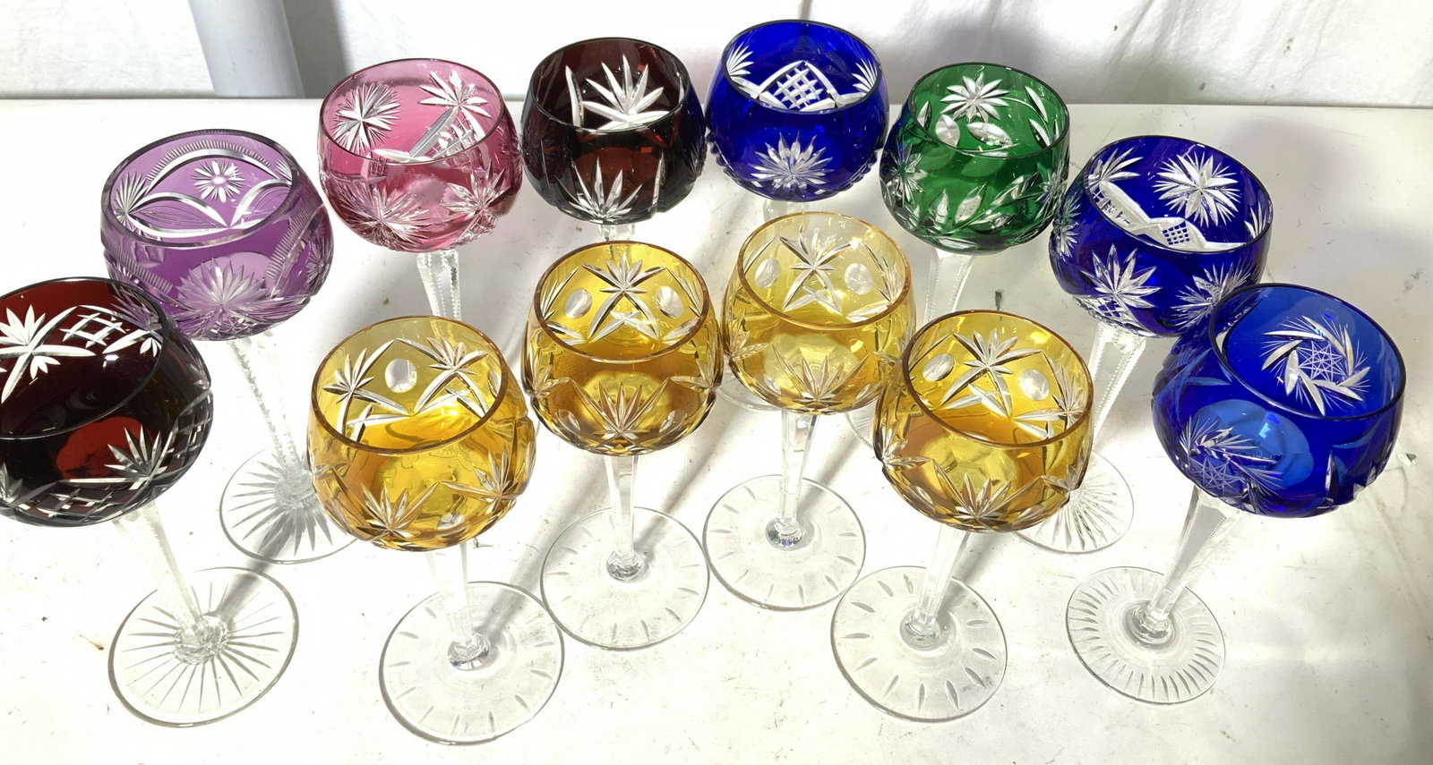 Multi Chrome Bohemian Cut Crystal Stemware 12: Near Set of Crystal pedestal goblets, hand formed Ruby red, cobalt blue, emerald green, sapphire pink, sapphire yellow, & light amethyst. Cuts of stems and glass patterns are similar yet distinguished