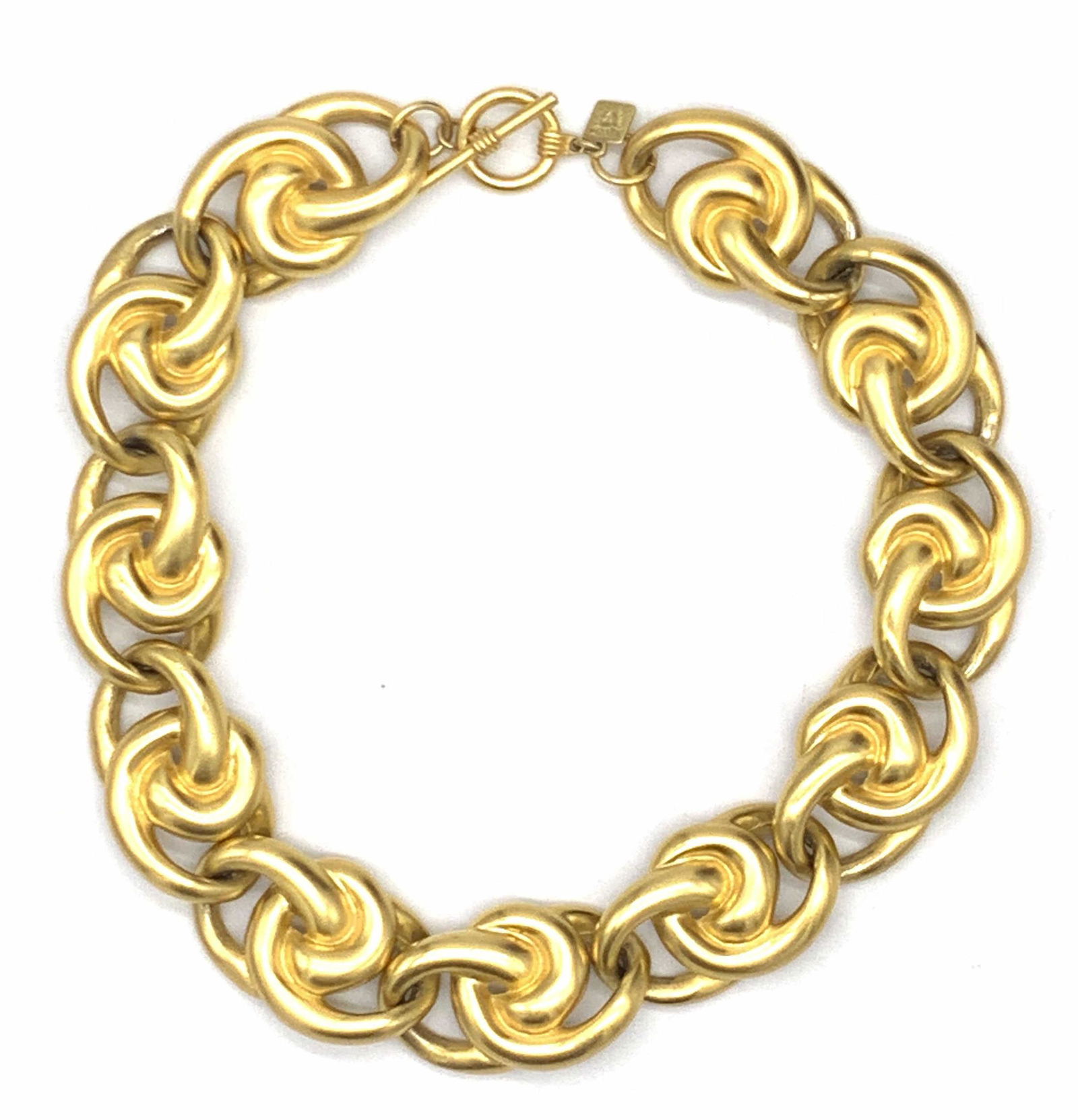 ANNE KLEIN Chunky Choker Necklace, Jewelry: A gold tone metal chunky choker necklace. The piece features interlocking links and secures with a toggle clasp closure. Adjacent to clasp is a charm that reads Anne Klein. Length approx. 17 in. Piece