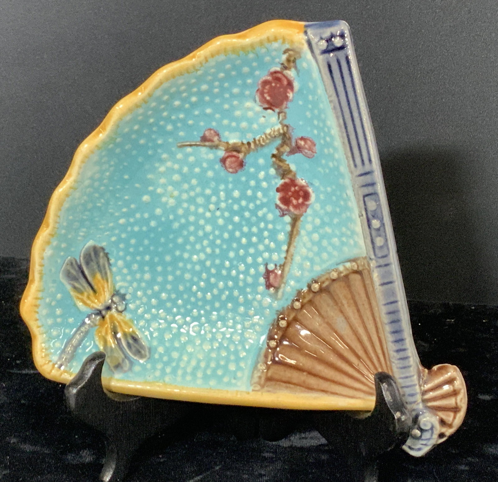 ASIAN DRAGONFLY MAJOLICA FAN Shape Pottery: An early Majolica plate , hand crafted in the shape of a hand held fan, paste up decor and raised illustrations of dragonfly and Asian blossoms. Hand painted, hand glazed pottery, No markings or inscr