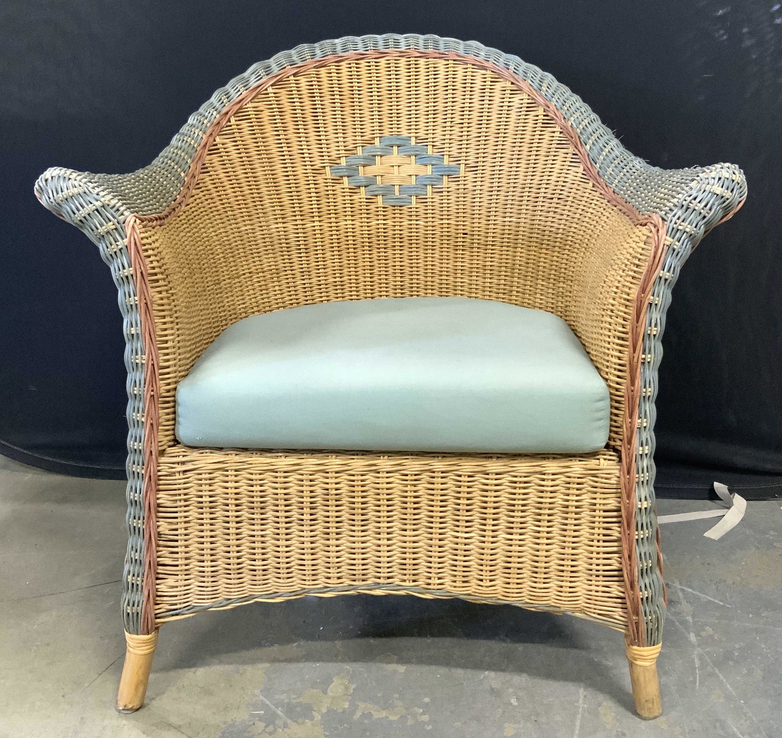 Outdoor Woven Wicker Armchair W Cushion: Armchair is woven wicker. Piece has tones of beige, light brown, & green. Armchair includes light green toned seat cushion. Armchair measures approx 34 inches tall 31 inches wide 30 inches deep. Armch