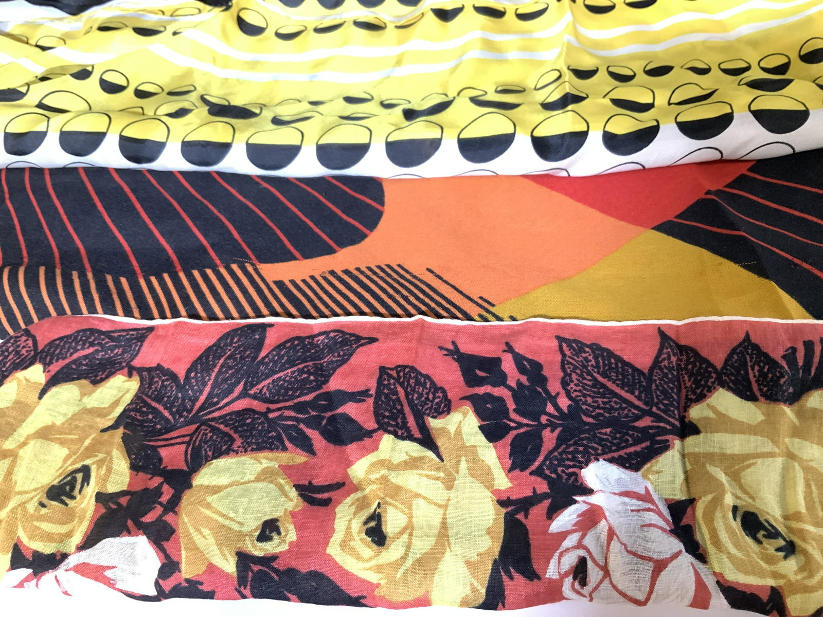 Lot 3 Mid Century Ladies Scarves: Silk, cotton, and polyester, c. 1970s. Yellow Rose hankie style on rust background, 15 in. deco Abstract lines in red, yellow and orange on black, 10.5 x 51 in., wear to fabric. Art Deco silk yellow, 