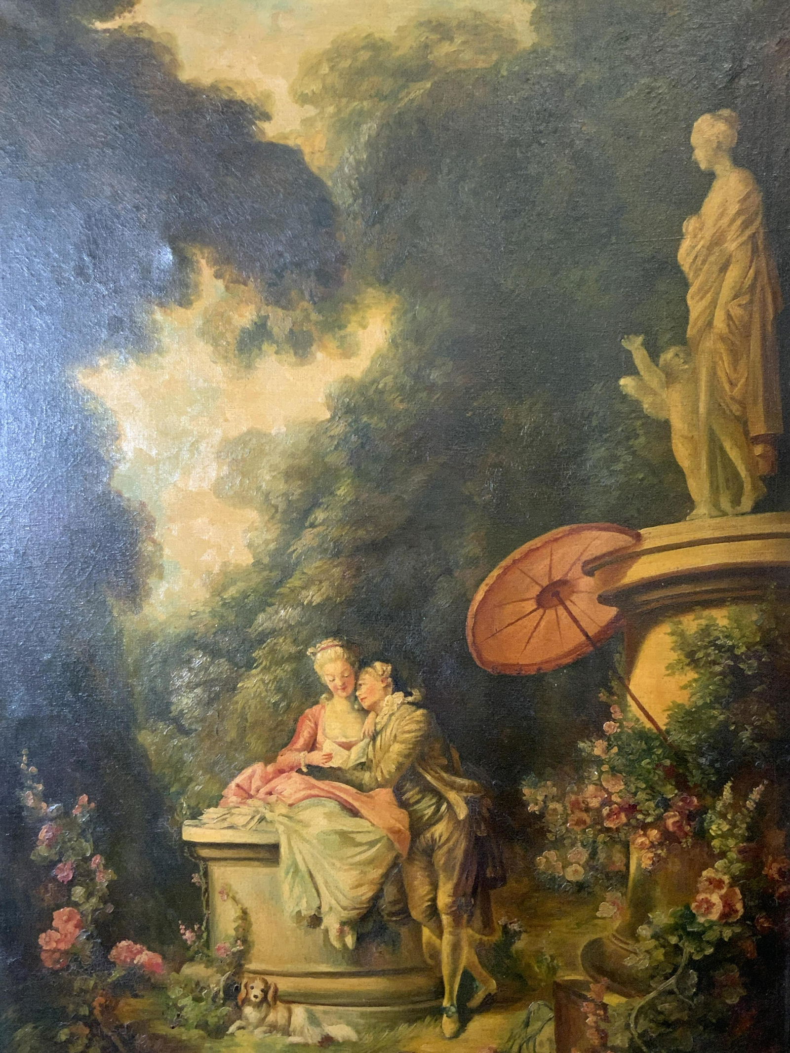 Oil on Canvas Rococo Style Garden Scene: Oil on canvas Rococo style garden scene, no apparent inscriptions or markings, subject a couple reading in a garden with a dog sitting at their feet, white painted wooden frame with traces of gilding,