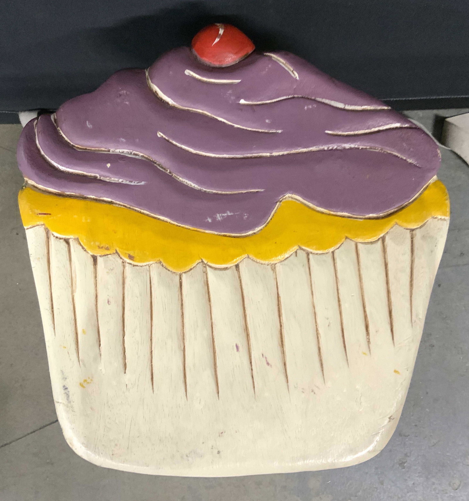 THAI INT’L HANDICRAFT Wooden Cupcake Stool: Underside of stool reads THAI INT’L HANDICRAFT. Piece is vintage & wooden. Top of stool is painted and carved to resemble a cupcake. Piece appears to be hand painted. Piece measures approx 12 inches