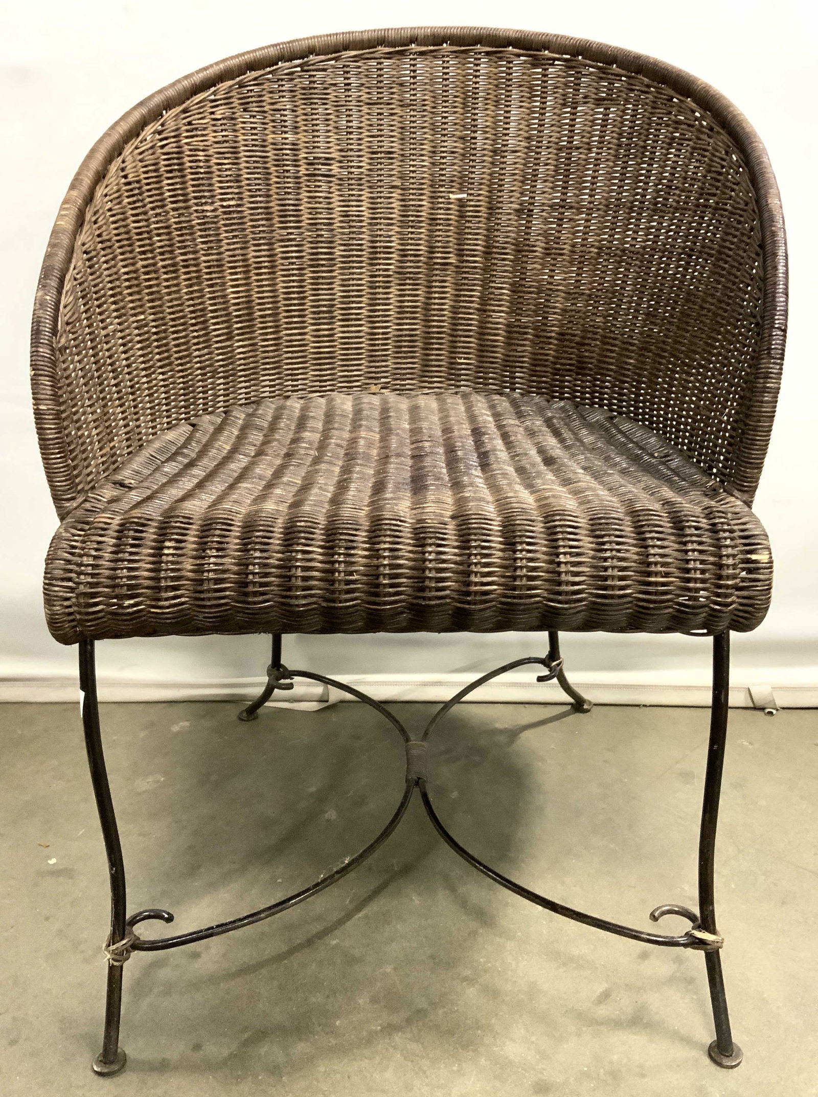 Woven Wicker Barrel Back Chair W Metal Frame: Chair is has metal frame W woven wicker structure. Piece is chocolate toned with barrel style backrest. Legs are metal with slight curves & have c curve shaped stretchers in betwee. Piece measures app
