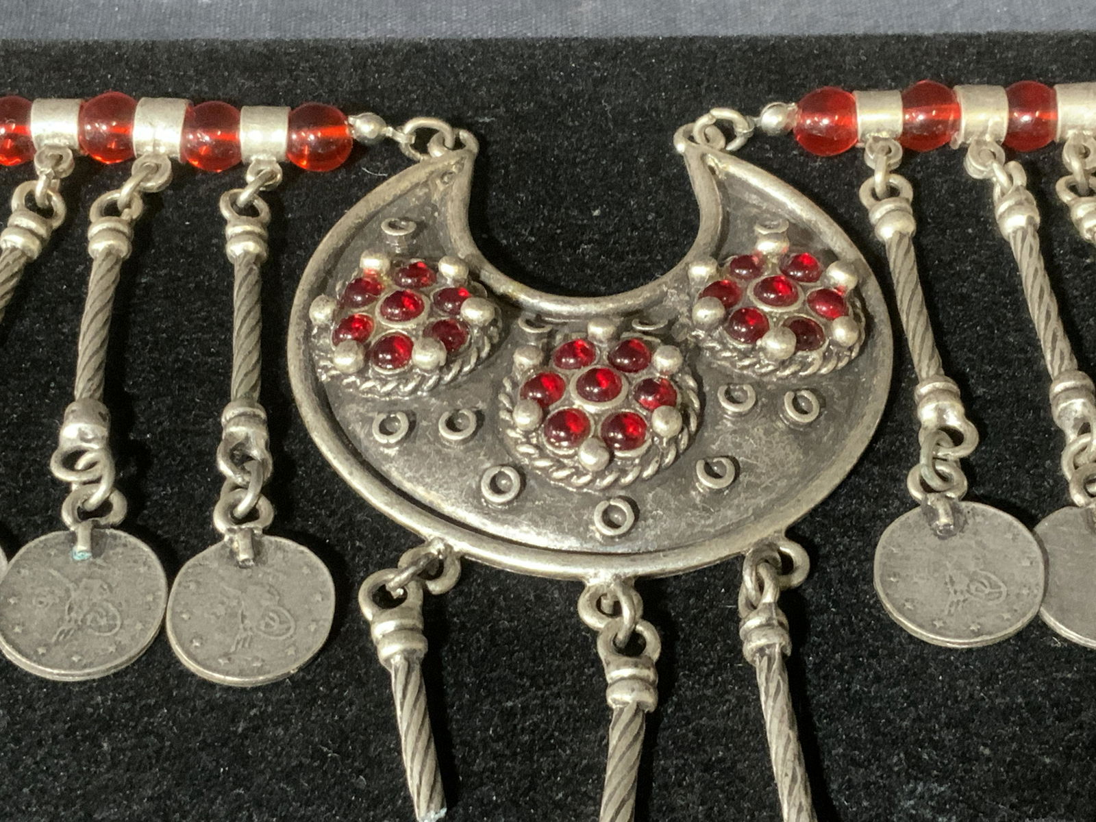 Crescent Moon Beaded Dangle Necklace: Crescent Moon Beaded Dangle Necklace, no apparent inscriptions or markings, necklace is made of a silver toned metal, neckalace has multiple red beads and coin like beads decorating it, part of piece