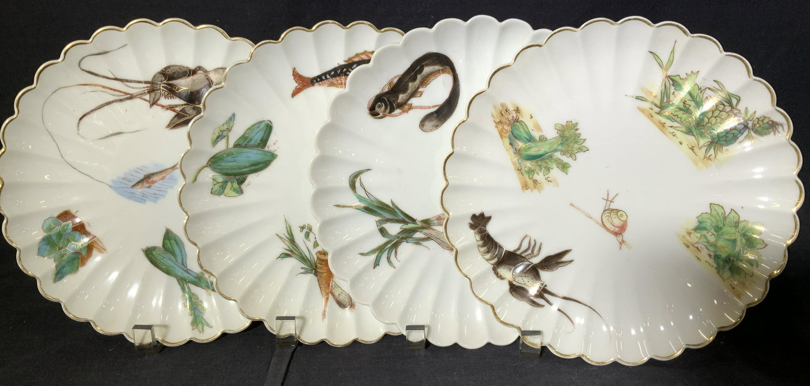 Set 12 CARLSBAD Fine Bone China Tableware: Hand painted porcelain fish dishes with scallop gilt trim rim. Each dish has a different hand painted sea creature and vegetable. On the back of each plate has a hand painted smiley face style logo an