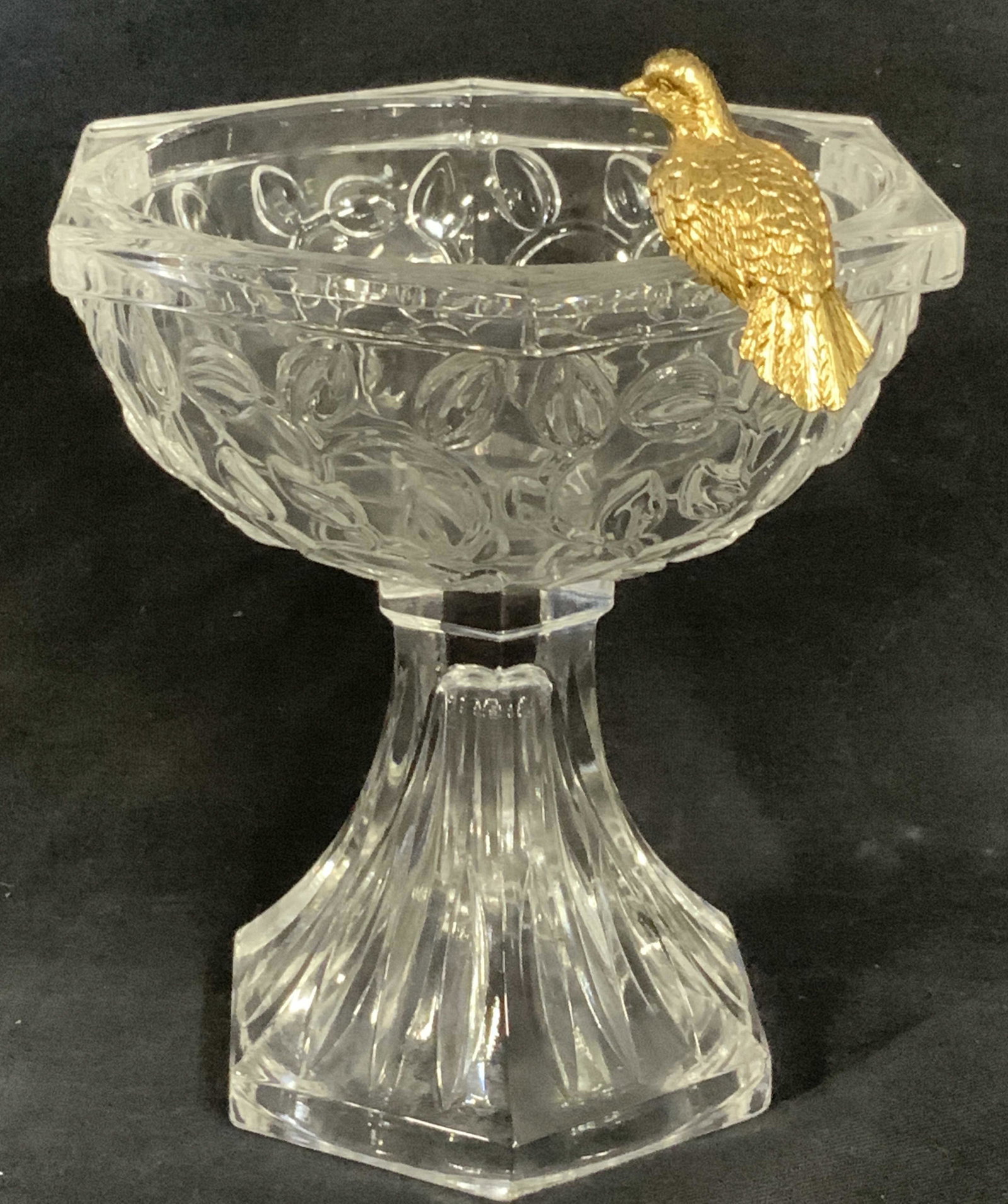 Embossed Glass Pedestal Chalice w Bird: A beautiful decorative art glass piece. Cut Glass pedestal and embossed vine pattern on exterior of chalice cup. Brass and gilt bronze bird is perched on the rim. Vintage piece. 6 in. Ht, 7 in w/ bird