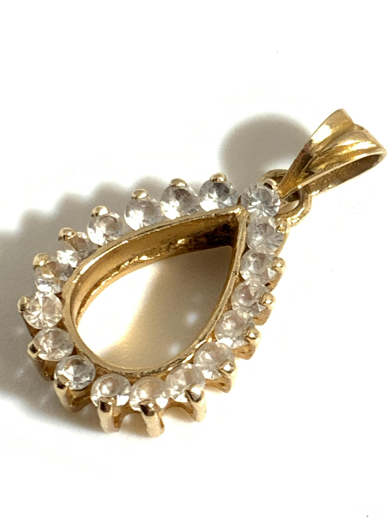 Vntg 14K Gold Quartz Gemstone Teardrop Pendant: A yellow gold pierced teardrop form pendant rimmed with prong set clear faceted quartz gemstones. Marked 585 (14k gold). Approx. 1L x .5W inches, measurement includes bail. Total weight 1.6 grams. Som