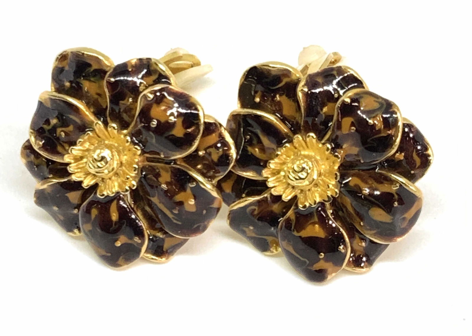 ERWIN PEARL Enamel Clip On Earrings W Dust Bag: A pair of gold tone metal floral form earrings decorated with earth toned enamel work. Pieces feature layered and raised floral petals. Undersides possess clip on backings that read Erwin Pearl. Dust