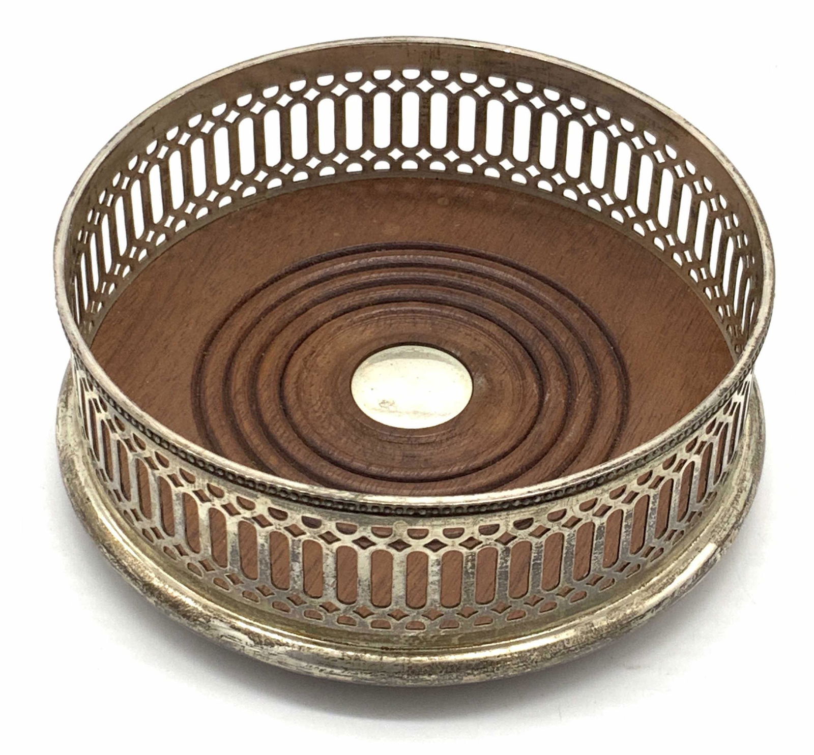 Vntg STERLING SILVER & Wood Wine Coaster: A vintage sterling silver and wood wine coaster. The piece features a brown carved wooden center rimmed with pierced sterling silver. Center of wooden piece has a circular sterling accent. The side is