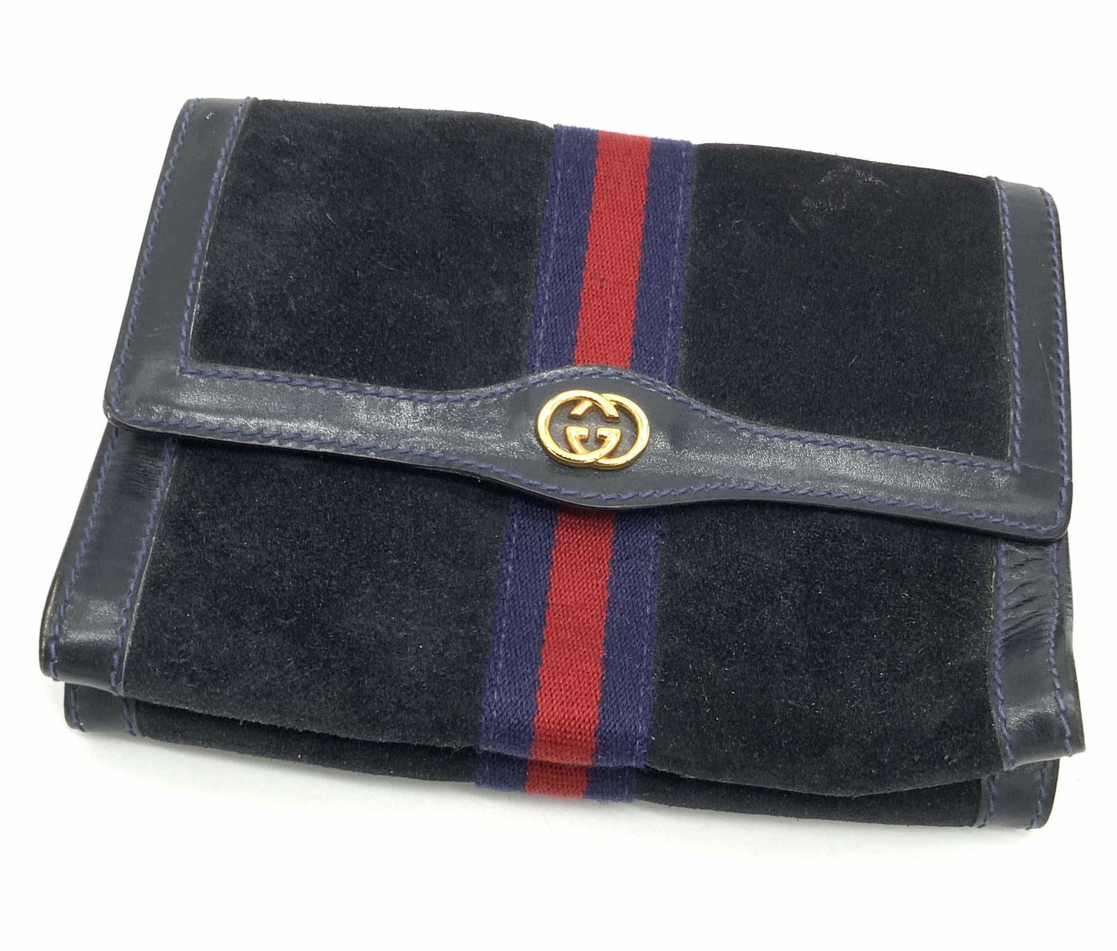 GUCCI Italian Cosmetics Bag / Clutch: A black suede and leather style clutch / cosmetics bag crafted by Gucci. The exterior of the piece is primarily black suede & leather style material. Fabric red & navy stripes down the center. Stitchi