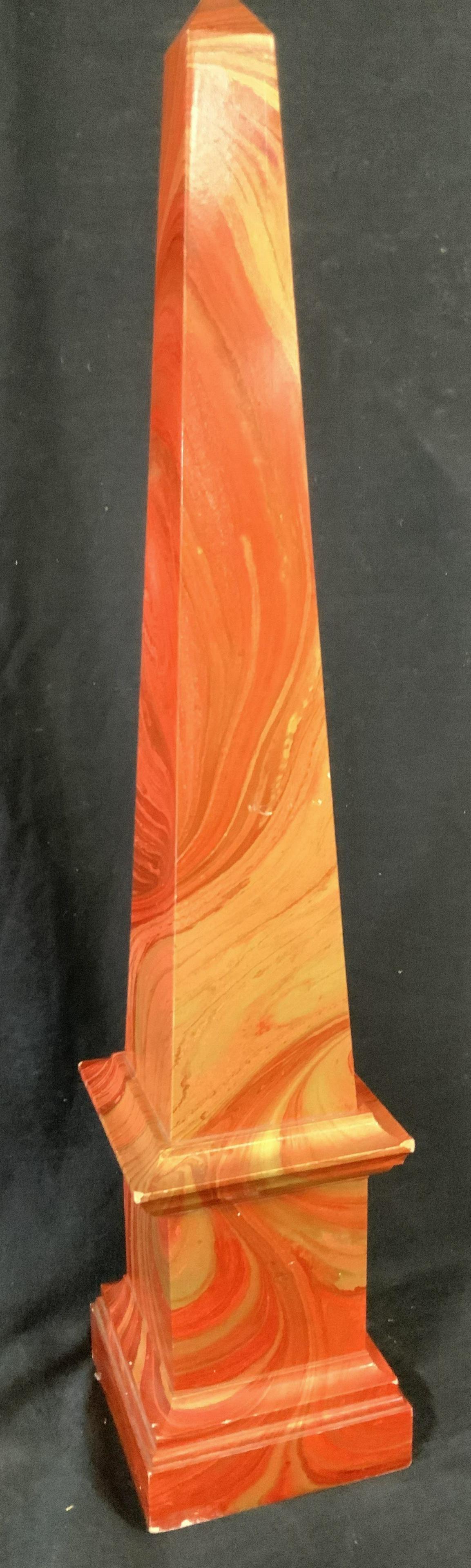 Hand Painted Lacquered Composite Obelisk, 23 in: This obelisk is a focal point with swirled red and gold paint that alludes to a marbled pattern. Underside hand written in ink E018000. Stands 23 in. , 4.5 in wide. Areas or worn pain on corners, unre