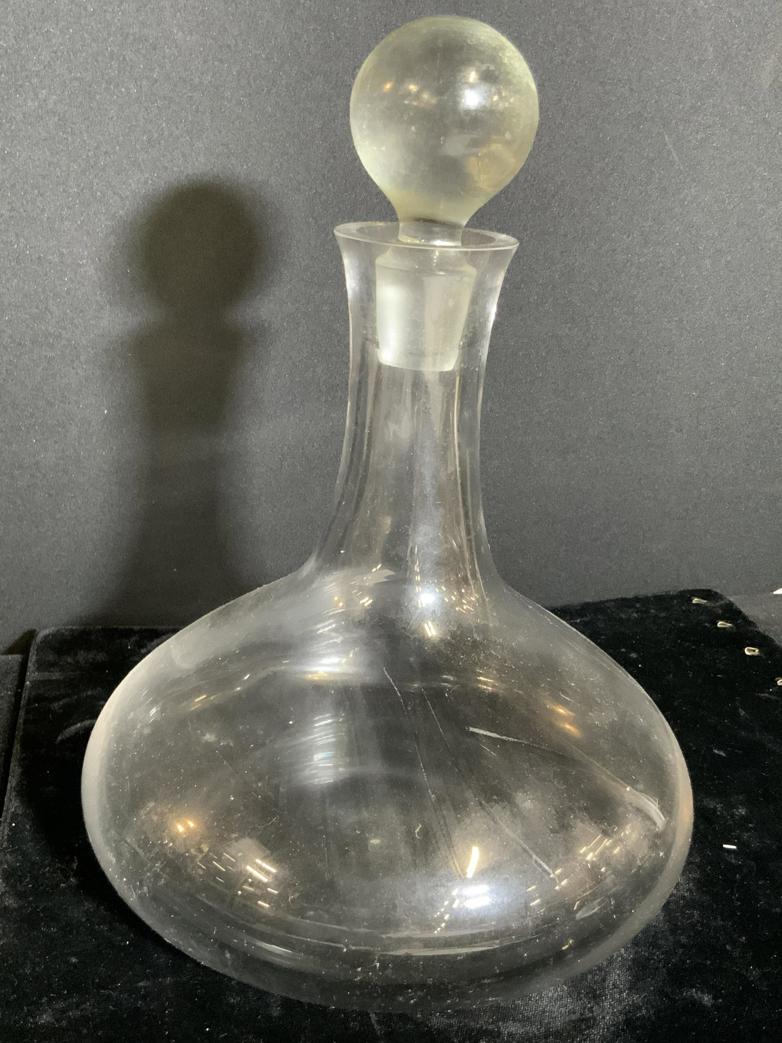 Clear Glass Ship’s Flask Style Decanter, Barware: A colorless clear glass ship’s flask style decanter. Stopper is spherical in shape. Possibly not original stopper as the fit is loose. Measurement taken with stopper approx. 10H x 7W in. Ship’s fl