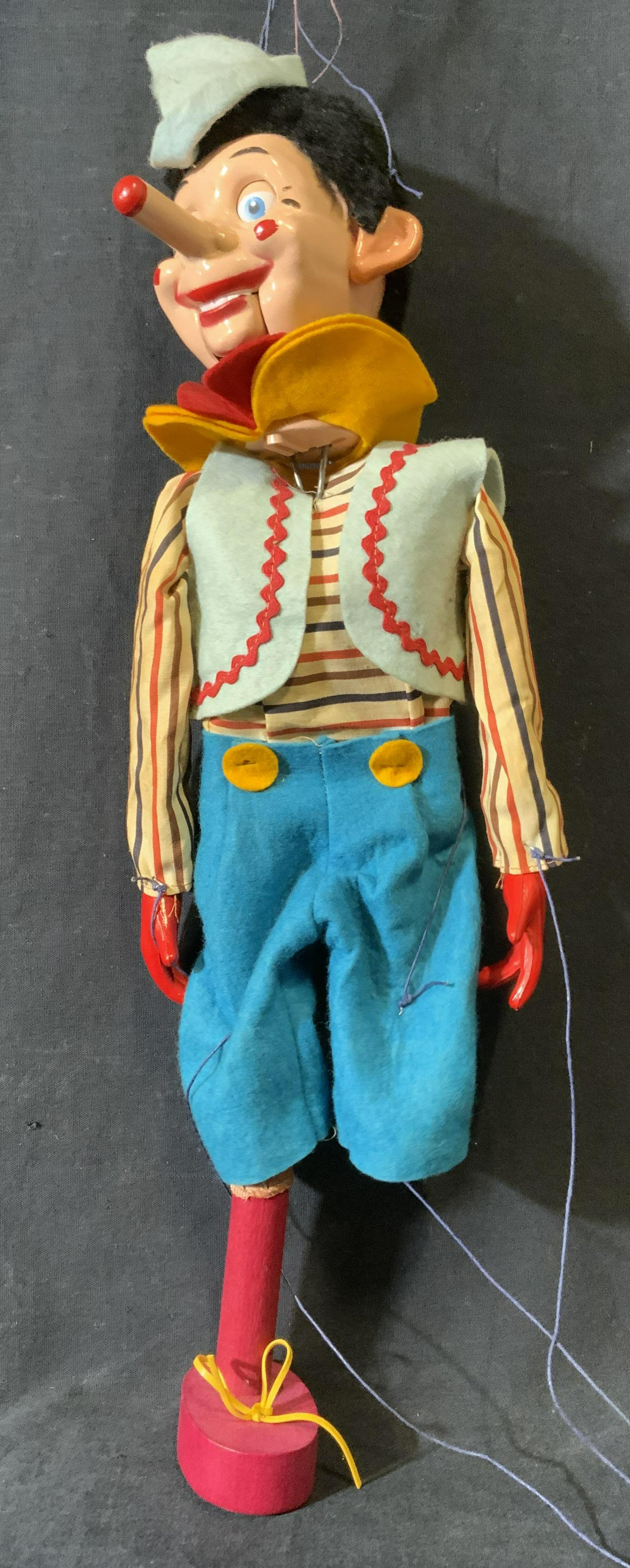 Vintage Wood Pinocchio Clown Marionette: Vintage Clown marionette. Mesh plumes around wrists and neck, felt hat, bells around ankles. Wear is consistent with age and use. Missing one leg, strings need reattaching. Measures approx 19.5 inches