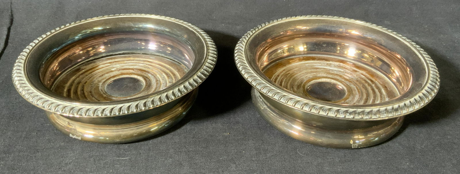 Pair BARKER ELLIS Silver Plated Wine Coasters: Pair BARKER ELLIS Silverplated Wine Coasters, inscriptions reads ‘England’, menorah mark to base, both measure 1 3/4 inches tall x 5 3/4 inches in diameter, surface wear and tarnishing to pieces,