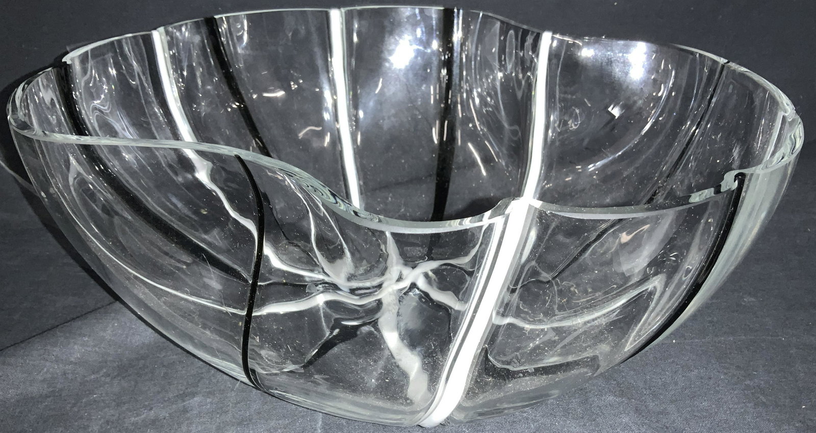 Mid Century Art Glass Centerpiece Bowl: And organic shaped thick walled art glass bowl with minimalist black and white colored accented lines radiating from the center. Use as fruit bowl, punch bowl, centerpiece, more. 12.25 x 11.5 at wides