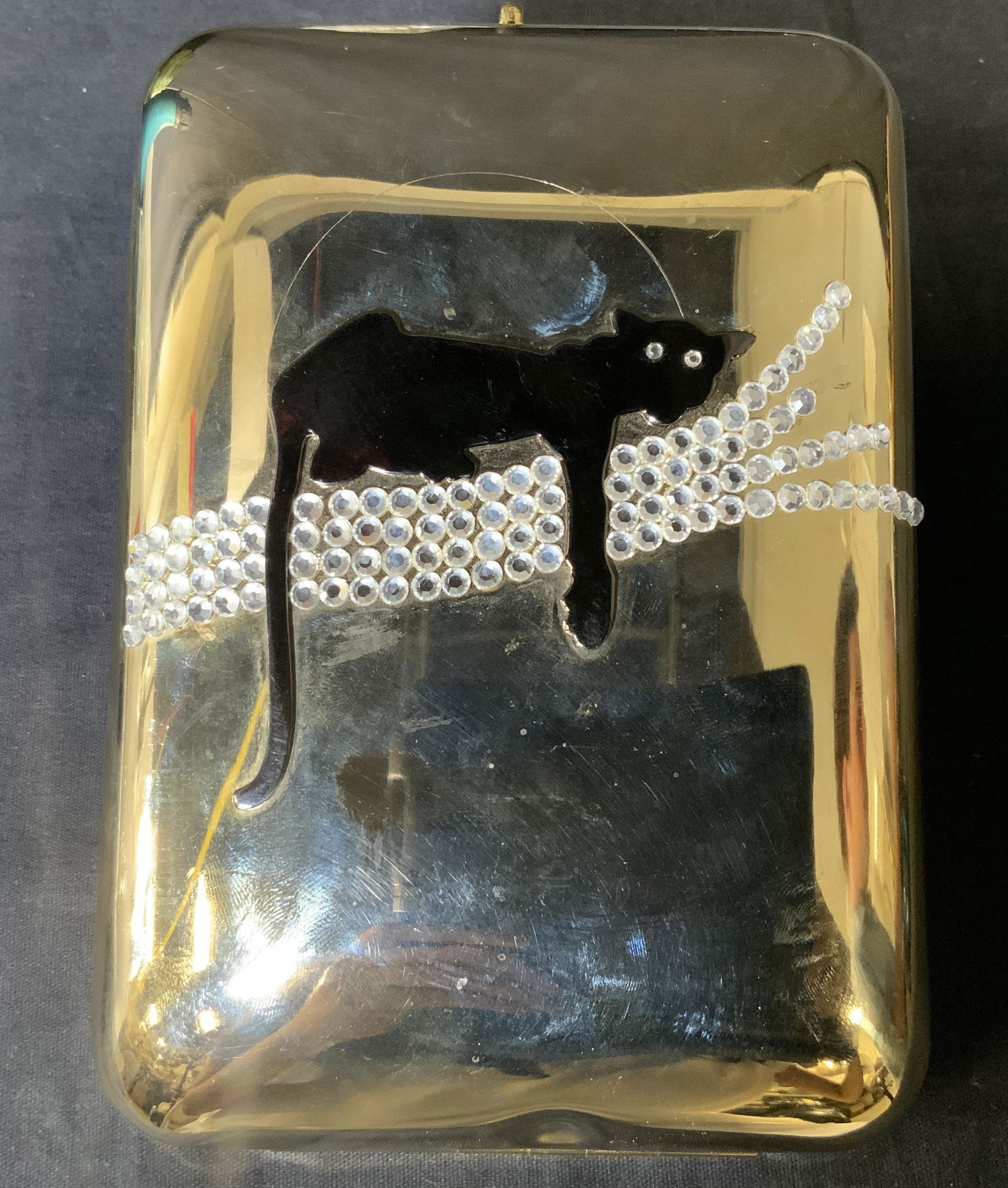 Metal Minaudière with Cat Figural: Metal Minaudière with Cat Figural, comes in dust bag, no apparent inscriptions or marks, measures 6 1/2 x 4 1/2 inches, drop measures 18 inches, surface wear and denting to metal, clasp needs repair,