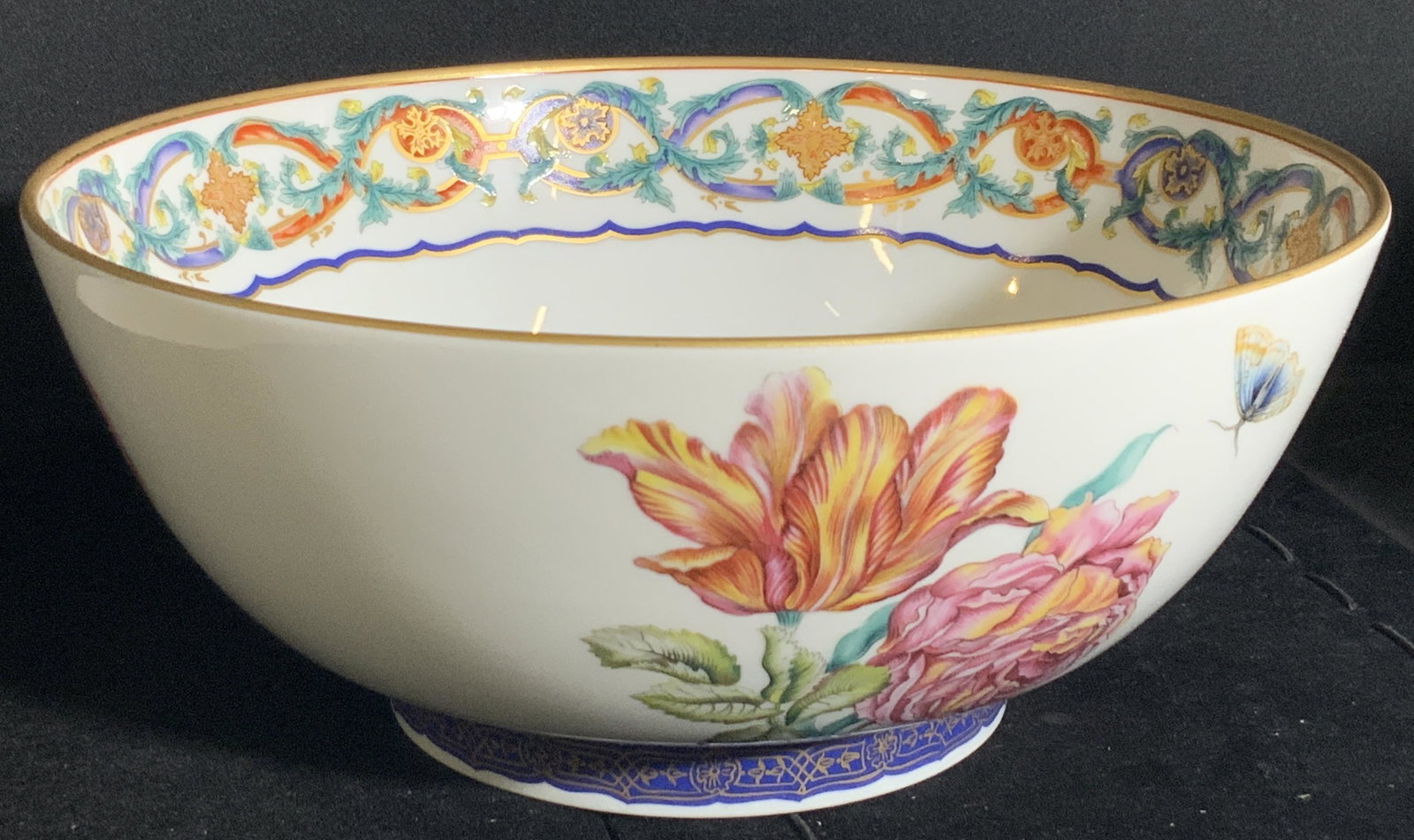 MILDRED R. MOTTAHEDEH Floral Porcelain Bowl: A white porcelain bowl featuring colorful insect and floral designs on both the exterior and interior. Gilt line work throughout. Underside is signed Mildred R. Mottahedeh, Portugal. Approx. 4.5H x 9W