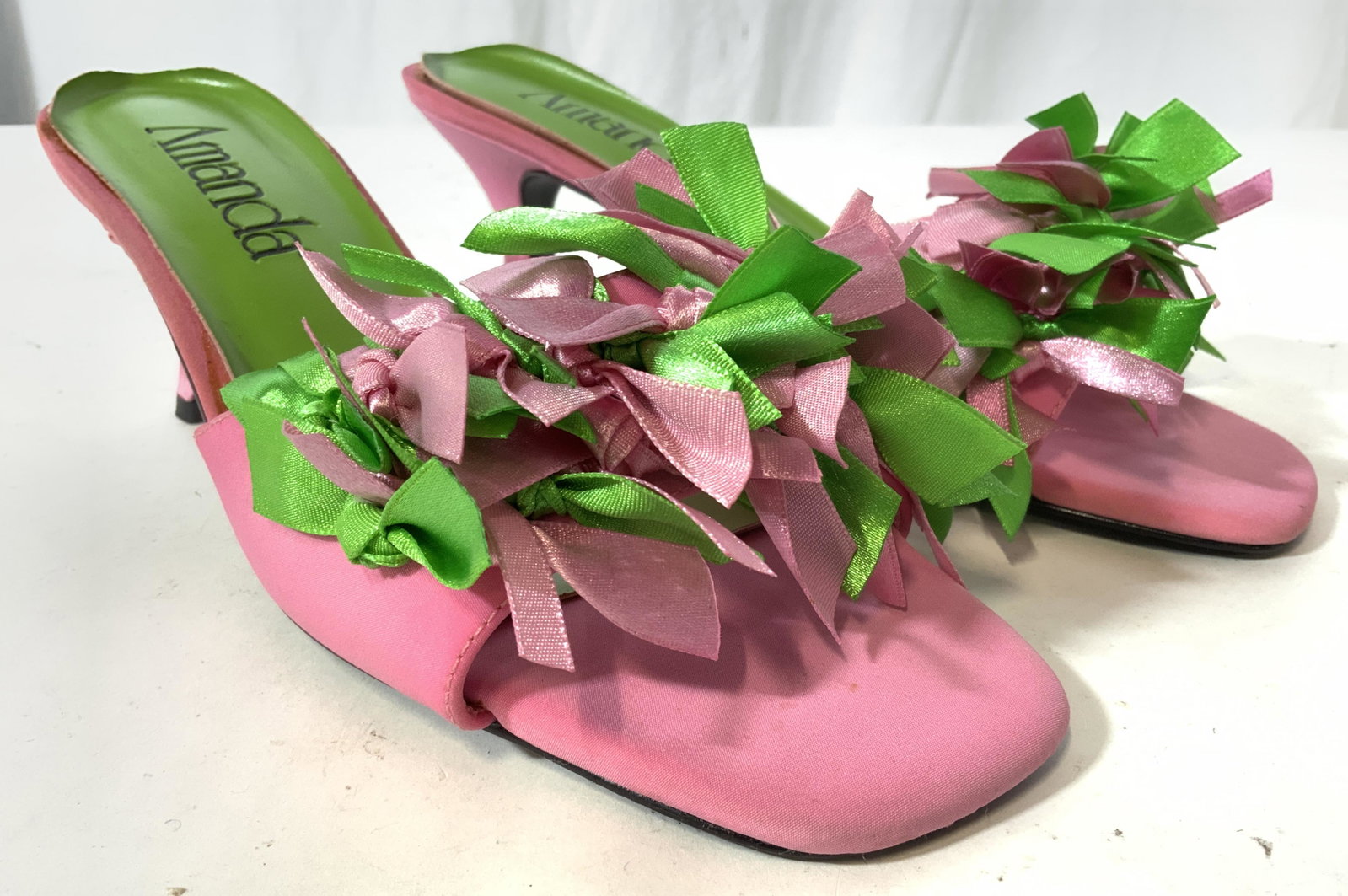 Pair AMANDA CONFETTI Open Toed Heels 9.5W: Size 9.5 wide. Undersides are marked AMANDA CONFETTI. Shoes have open toes with 2.5 inch heels. Shoe sole is green with black toned lettering. Heel & toe areas are pink toned. Toe area has pink & gree