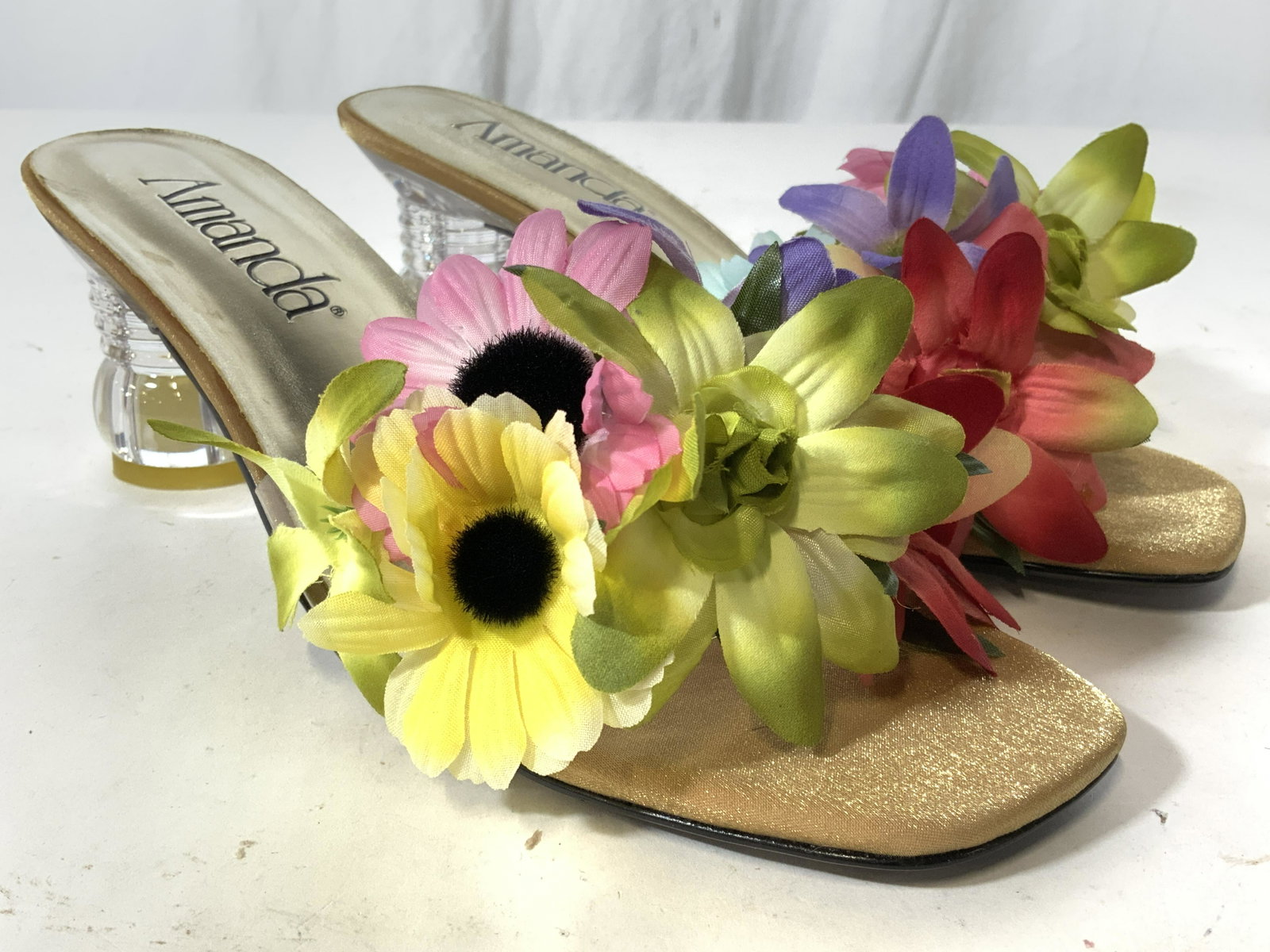 Pair AMANDA HOPE Open Toed Heels 9.5W: Size 9.5 wide. Undersides are marked AMANDA HOPE. Shoes have open toes with 2.5 inch heels. Shoe sole is gold toned with black toned lettering. Heel areas are clear. Toe area has multi toned faux flow