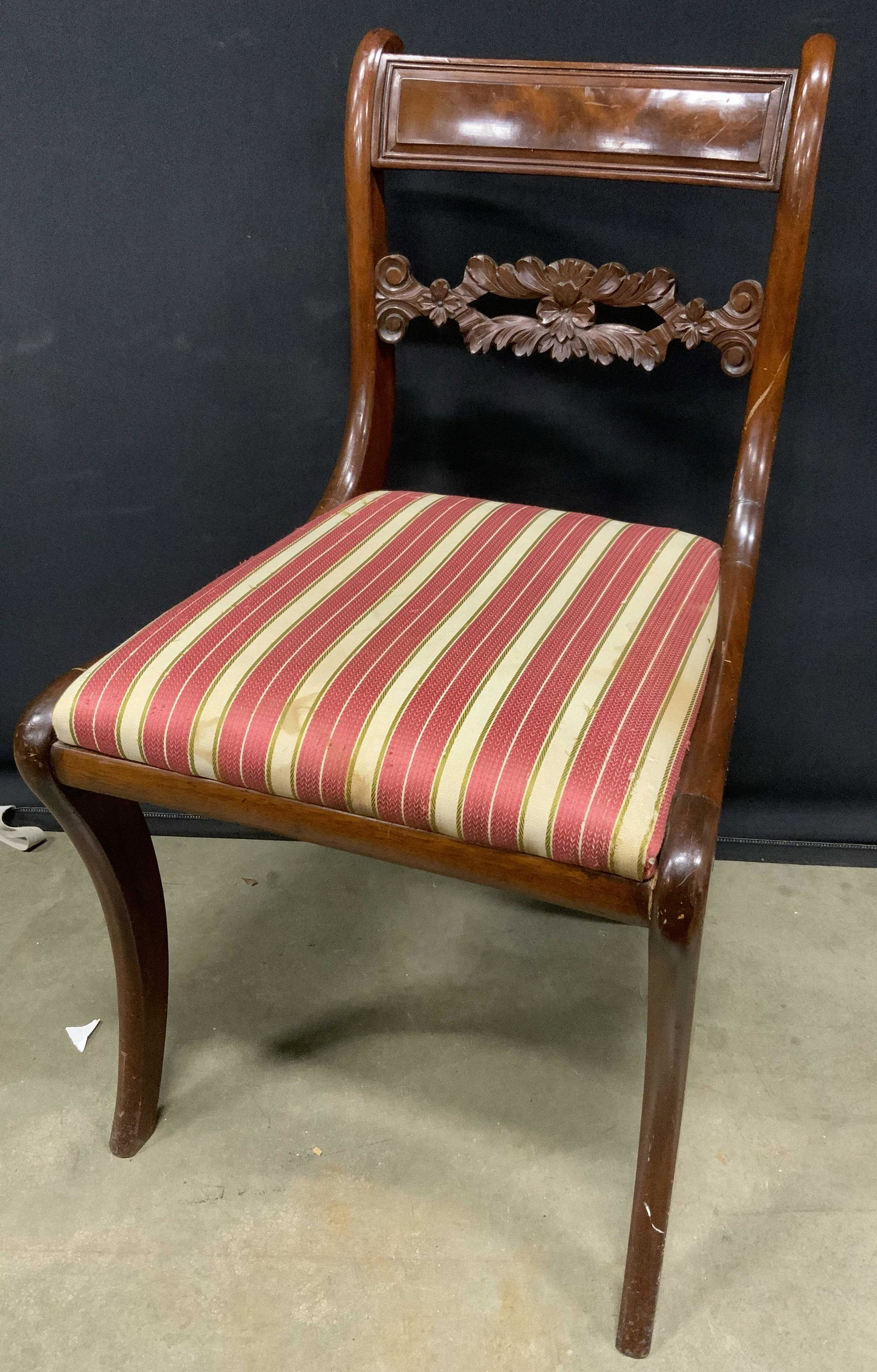 Carved Back Wooden Side Chair: Vintage carved back side chair, possibly antique. Upholstered seat, multi toned striations. Mahogany toned, possibly mahogany wood. Wear is consistent with age and use. Measures approx 32 inches h, 18