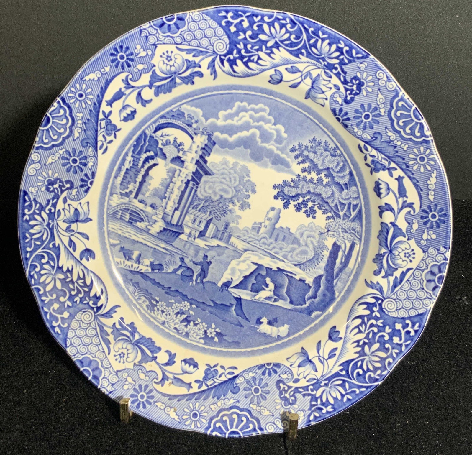 Vintage SPODE Collectible Porcelain Plate: A vintage collectible blue and white porcelain plate crafted by Spode. Slightly scalloped rim. Obverse design depicts people and animals resting and frolicking in a nature setting. Underside reads Spo