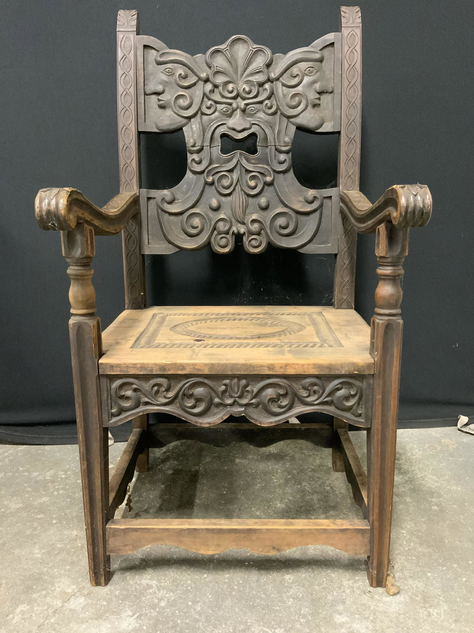 Vintage Intricately Carved Wooden End Chair: Chair is vintage possibly antique. Piece has intricately carved wooden detail depicting faces & geometric detail. Chair legs have box stretcher in between. Measures approx 46 inches tall 26 inches dee