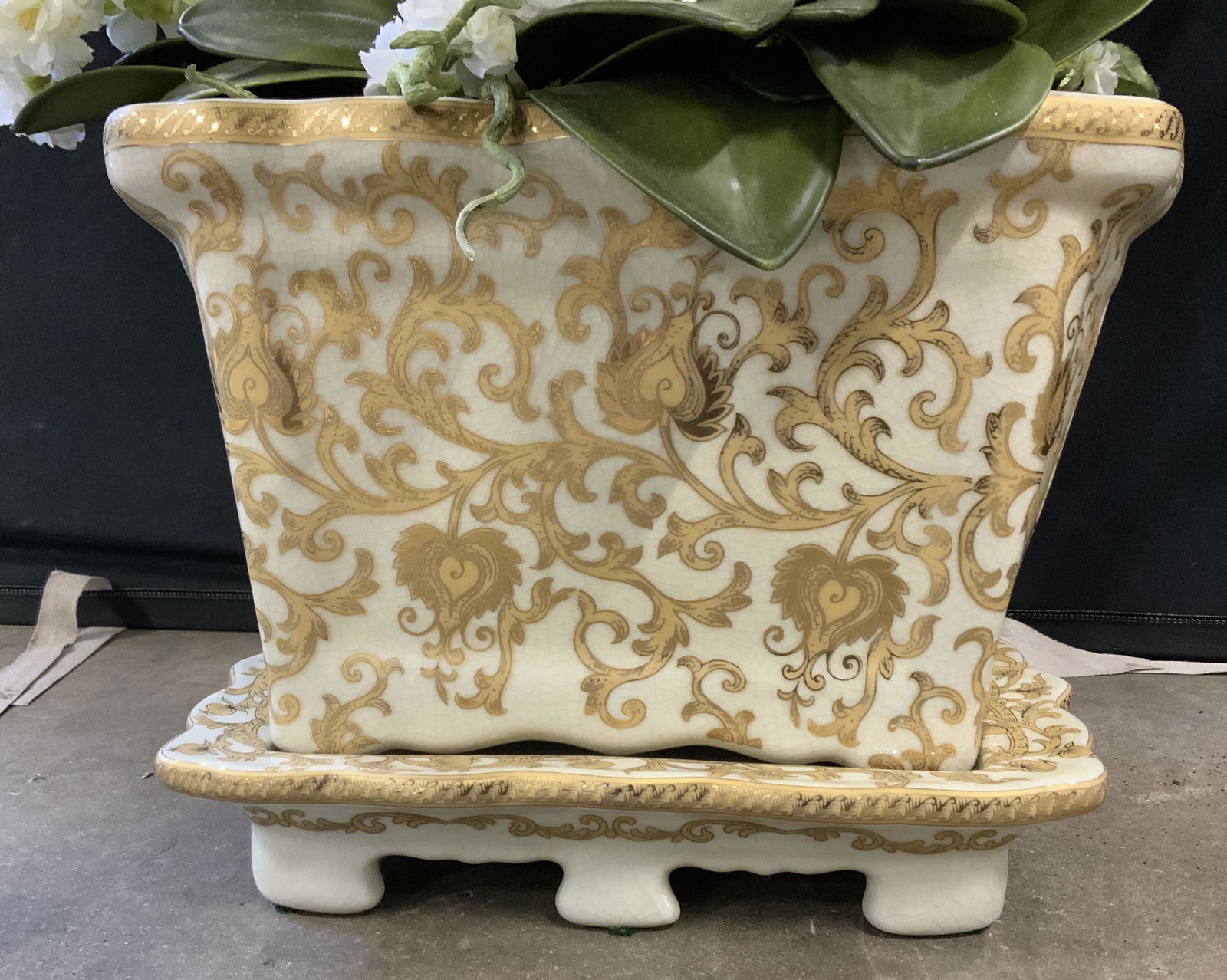 Porcelain Planter & Large Silk Flower Arrangement: White porcelain centerpiece, possibly vintage. Decorated with gilt scrolled floral and leaf designs. Includes a matching footed platform base. Houses a large silk flower arrangement. Wear is consisten