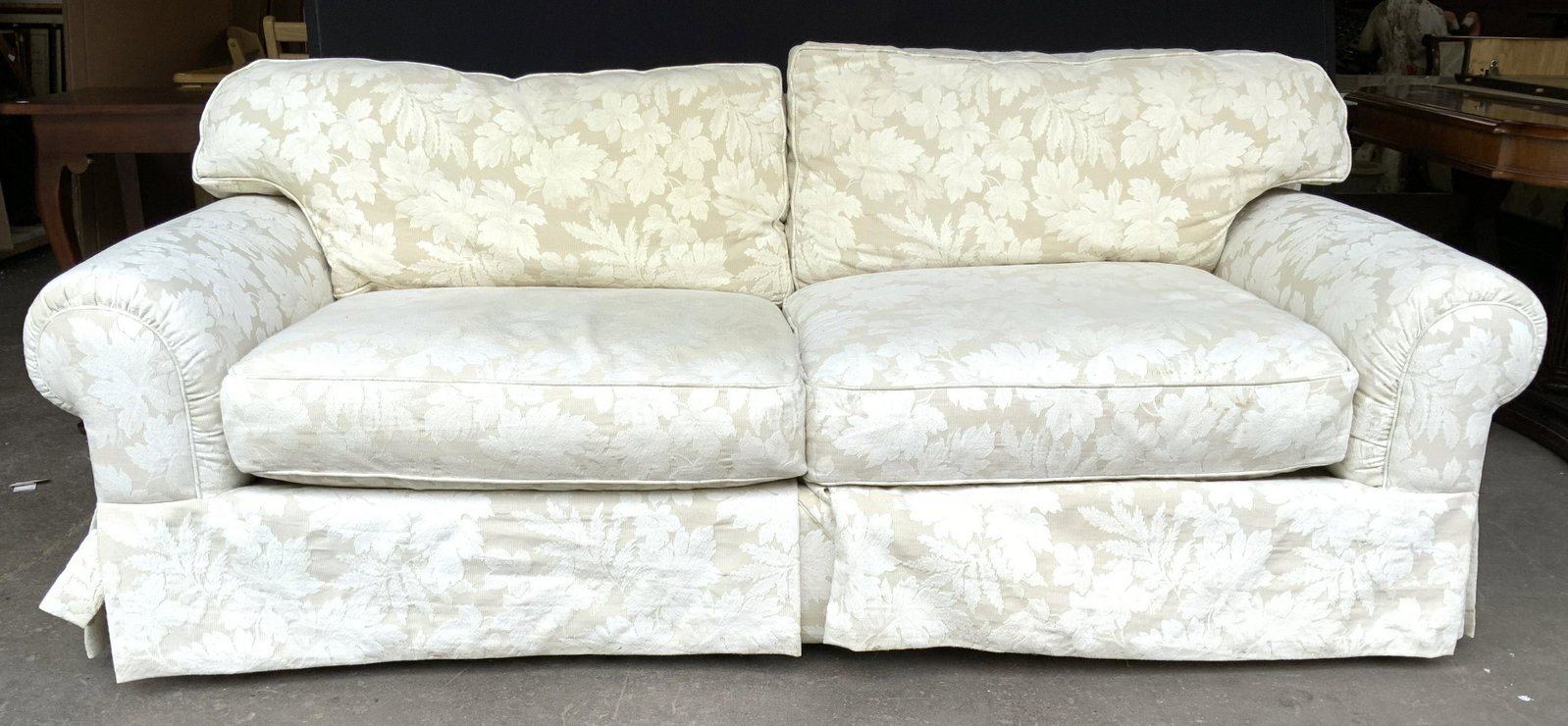 MACYS MODERN CONCEPTS Vintage Skirted Sofa: Tag read MACY’S MODERN CONCEPTS. Sofa is vintage & skirted. Piece measures approximately. Sofa is cream toned with floral & leaf detailed upholstery. Sofa, couch, macys modern concepts sofa, vintage