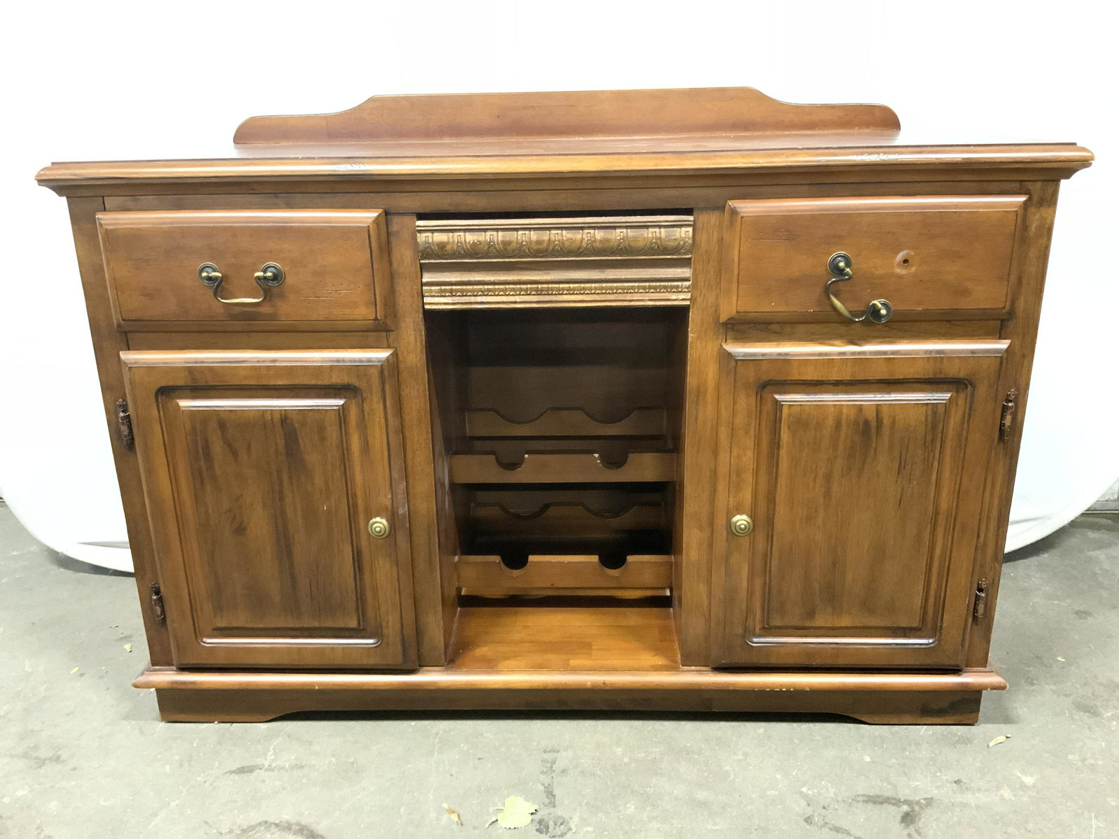 Vintage Wooden Bar W Wine Rack & Drawers: Bar is vintage and wooden. Piece has 2 drawers, 2 cabinets & 4 wine bottle areas. Piece has small back panel. Drawers have gold toned metal handles. Cabinets have gold toned metal knob style handles. 