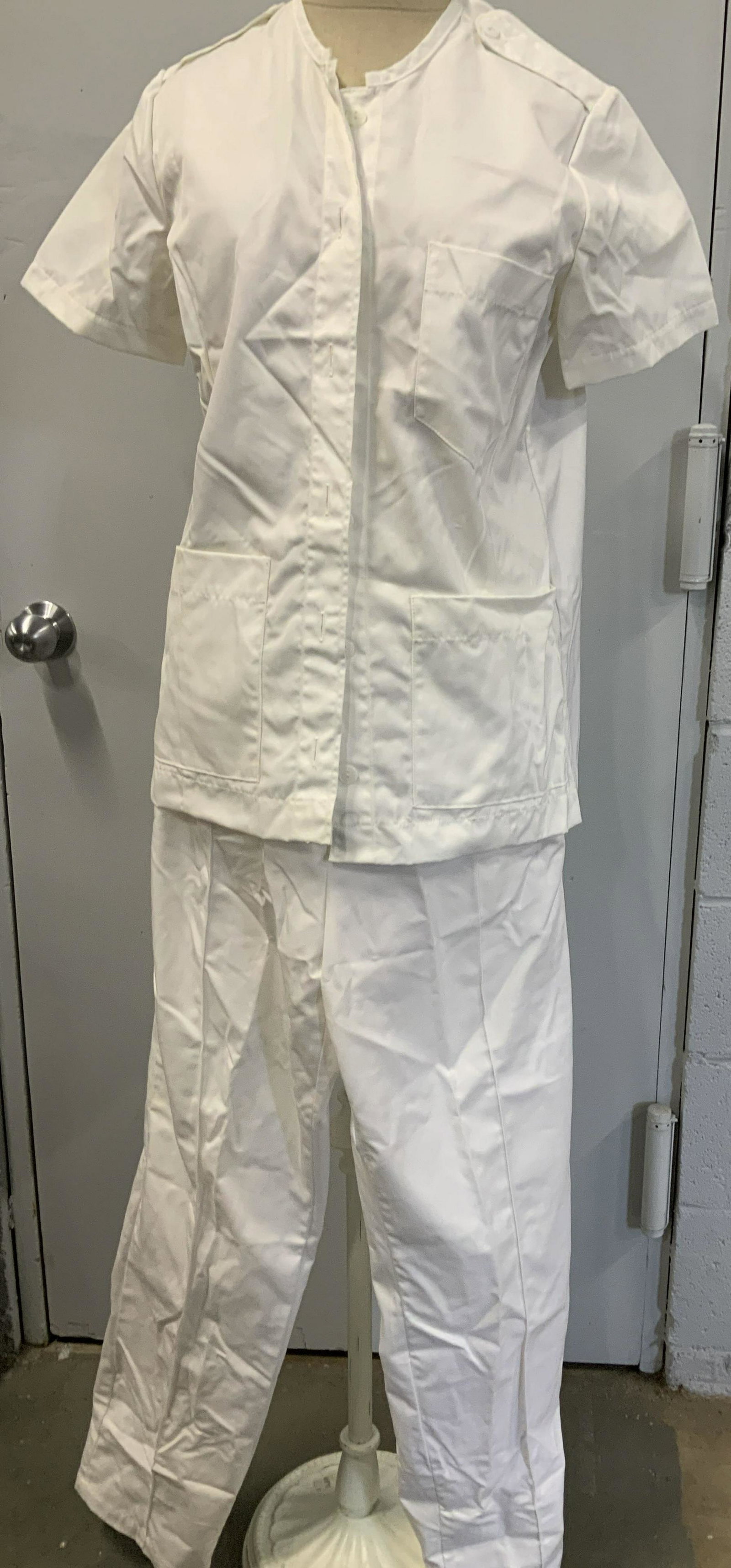Never Worn White Hospital Scrubs, 4 pcs: 2 sets of ladies hospital draw strong pants and short sleeve button up shirt. Size Small. High crew collar, hand pockets, chest pocket. Pants waist 24-38 in. Inseam 30.5 in. Backside pocket. All white