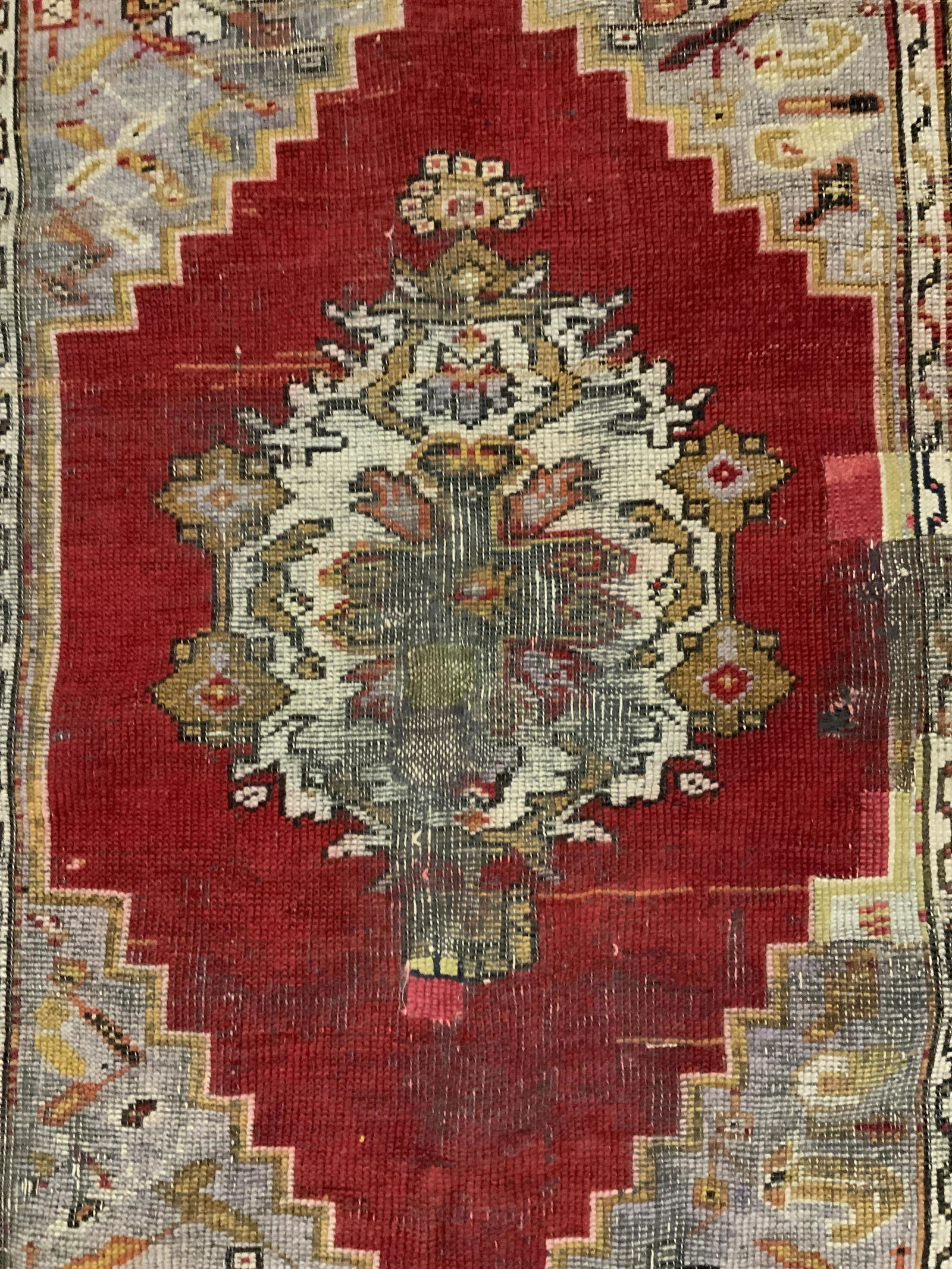 Vintage Hand Made Persian Rug: Vintage handmade rug, ends are fringed, possibly antique. Decorated with intricate multi toned floral and geometric patterns. Wear is consistent with age and use, tearing present. Measures approx 59 i
