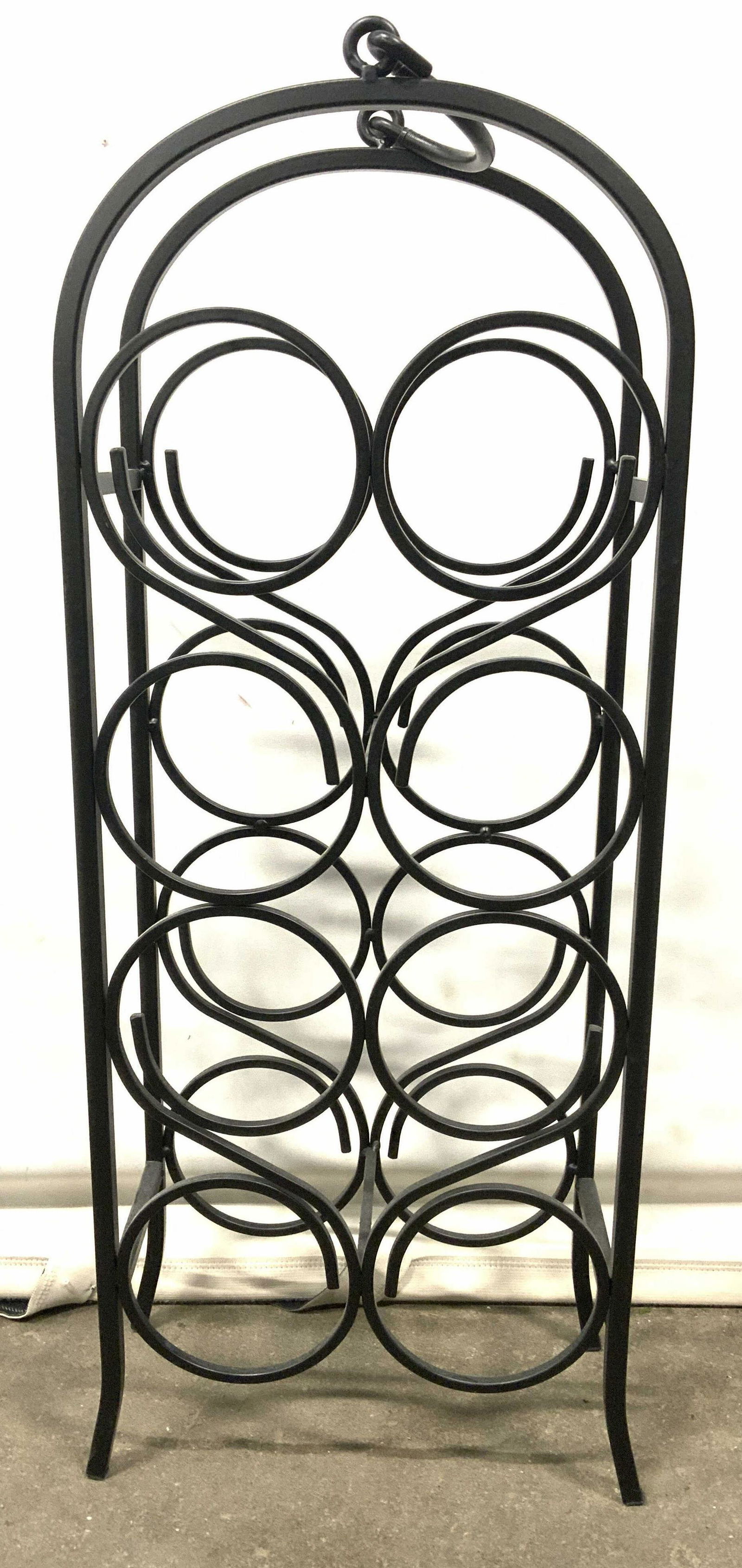 Metal 8 Bottle Wine Rack W Handle: Wine Rack is black toned & metal. Piece has 8 spaces for wine bottle. Top of piece is arched & has handle. Wine rack measures approx 29 inches tall 10.5 inches wide 6 inches deep. Wine rack, metal win