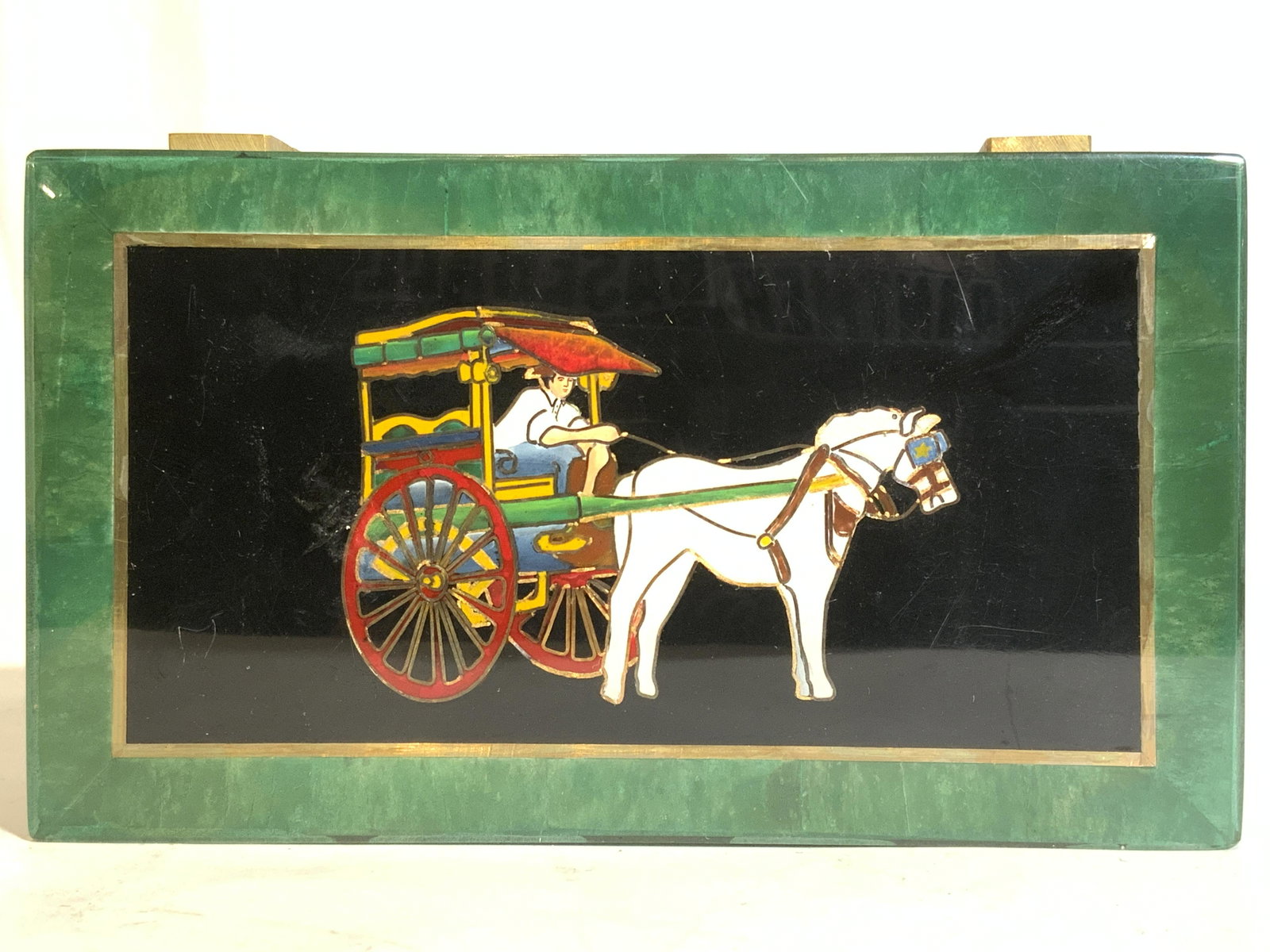 Philippine Jade Calesa Design Lidded Jewelry Box: Jewelry box has tag which reads MADE IN PHILIPPINES. Piece has hinged lid. Jewelry box has depiction of horse & buggy on lid. Structure of box is possibly Bakelite. Interior is lined with green toned 