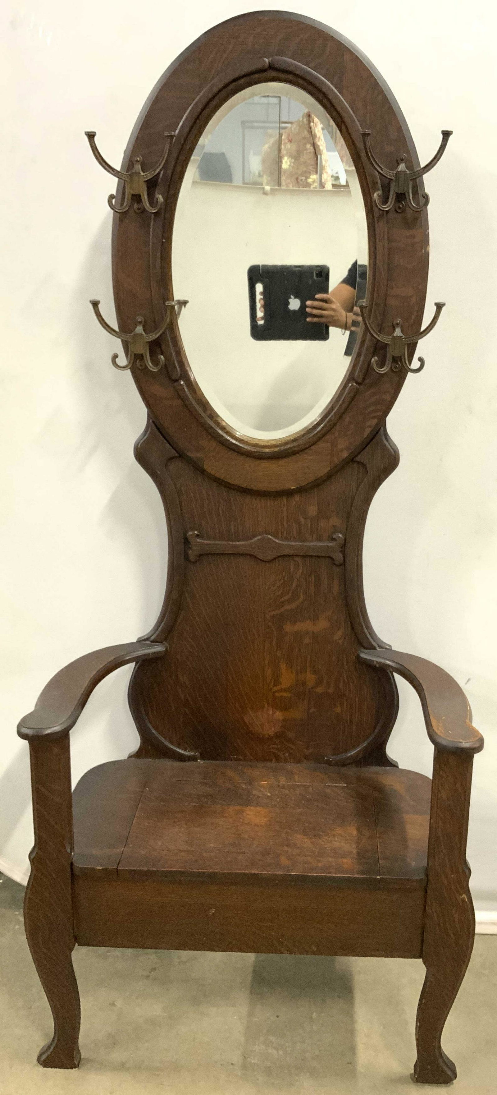 FILLEY & CRANE CO Antq Wooden Hall Stand W Storage: Backside has tag which reads FILLEY & CRANE CO. Hall stand is antique. Piece is brown toned and wooden with carved detail. Piece has bench area with lidded storage space & armrests. Piece has oval sha