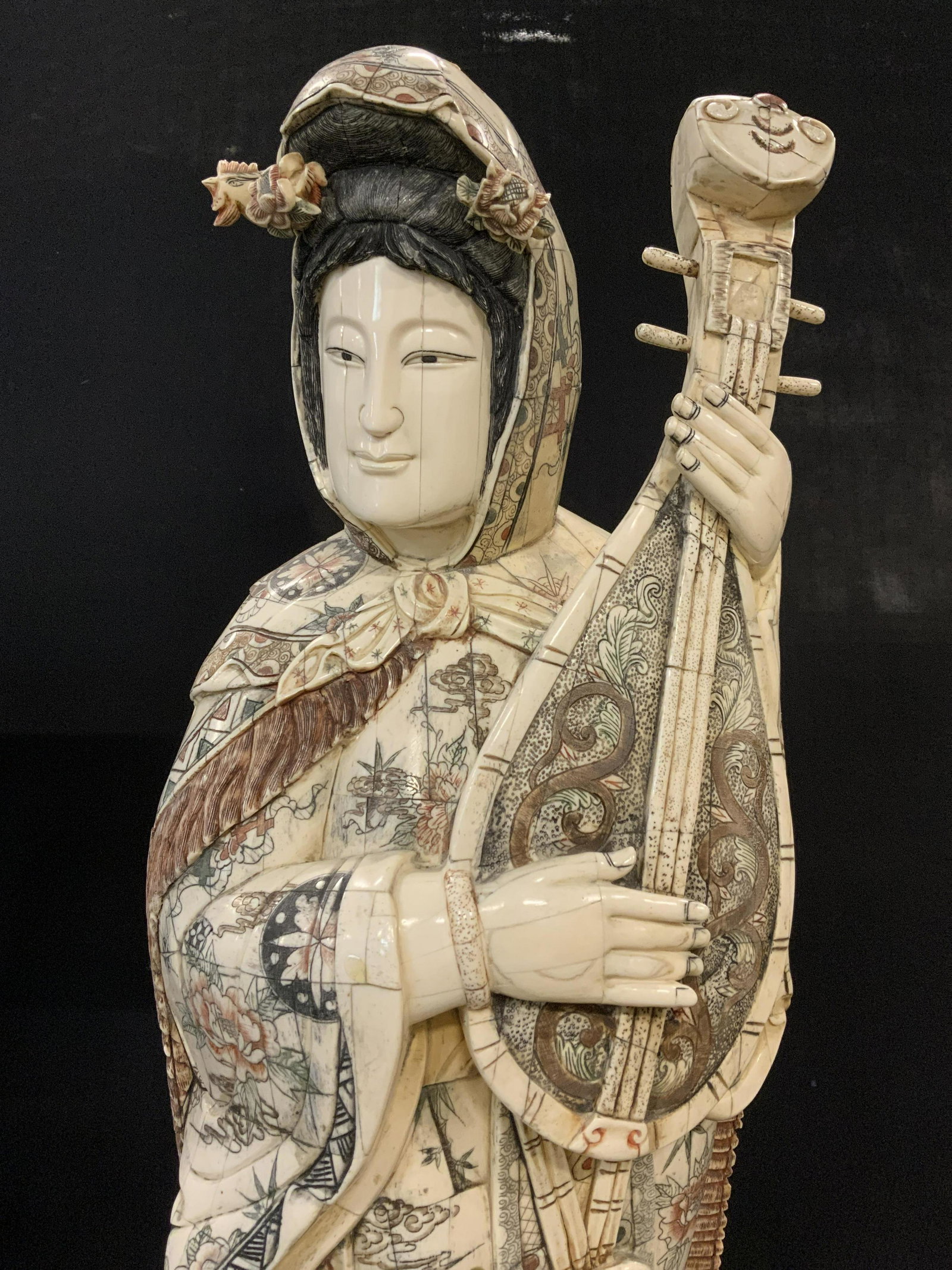 Floor Sized Asian Bone Tile & Wood Sculpture 40inH: Hand crafted bone tile on wood sculpture, Asian, possibly vintage. Hand etched detailing. Robes decorated with floral, and medallion patterns. Robed figure is playing a stringed instrument, a cape is 