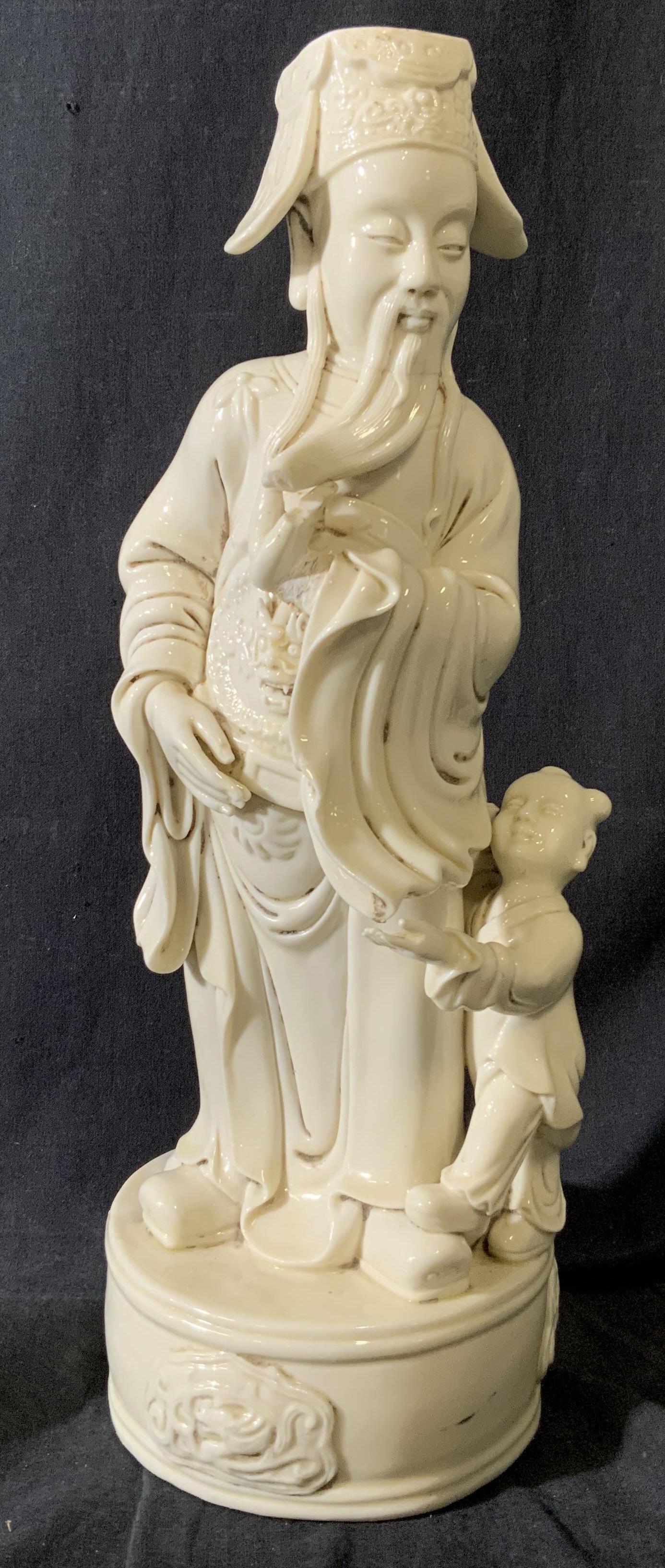 Blanc De Chine Asian Figural Man and Child: Blanc De Chine Asian Figural Man and Child, inscription on the back of man in Eastern Asia characters, subject is an Eastern Asian man standing next to a young child, measures 15 1/2 x 5 1/4 x 5 1/4 i
