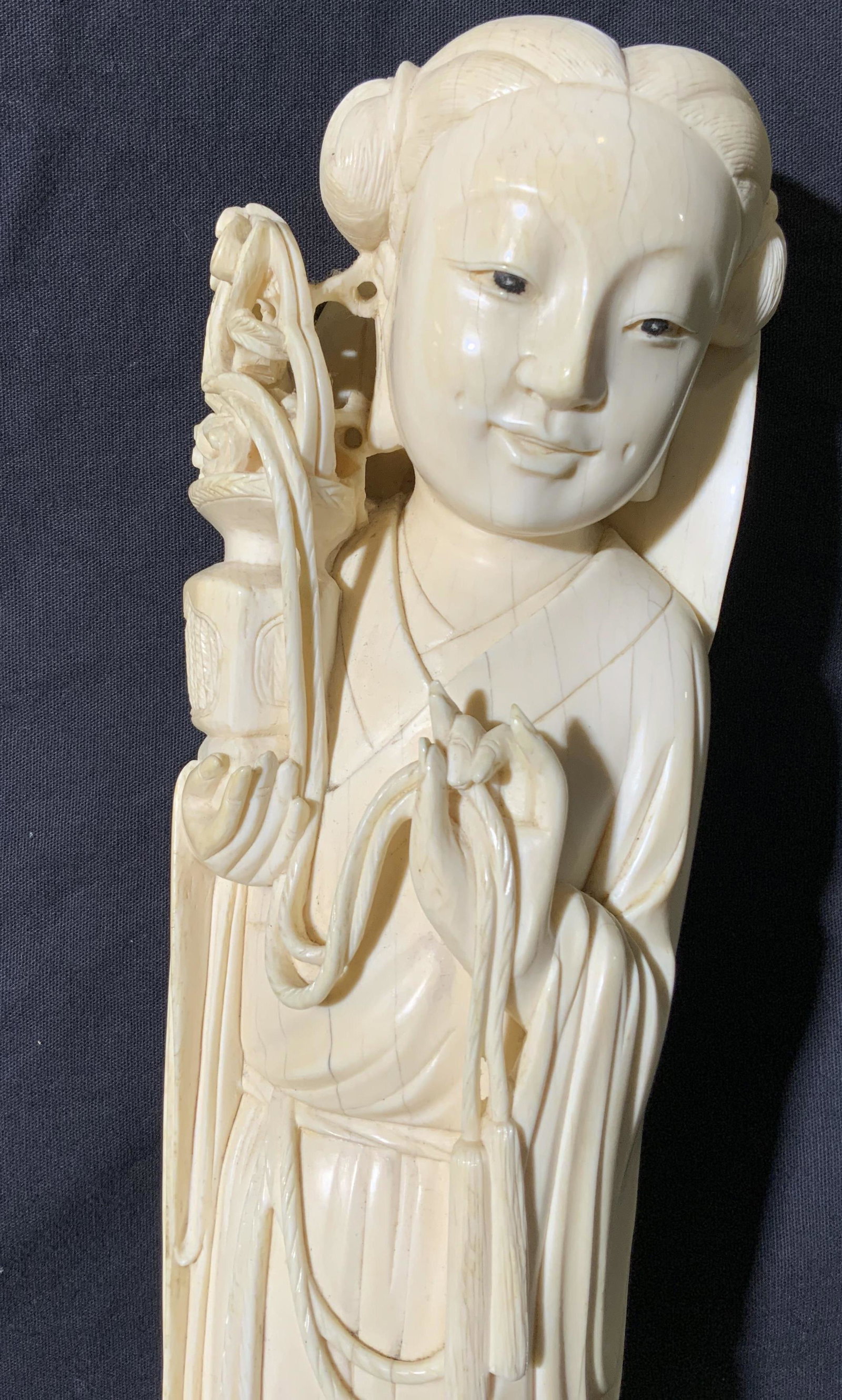 Bone Figural of Woman Holding Vase: Bone Figural of Woman Holding Vase, no apparent inscriptions or marks to piece, subject an eastern Asian woman standing with one hand displaying the katana mudra and the other holding a vase of flower