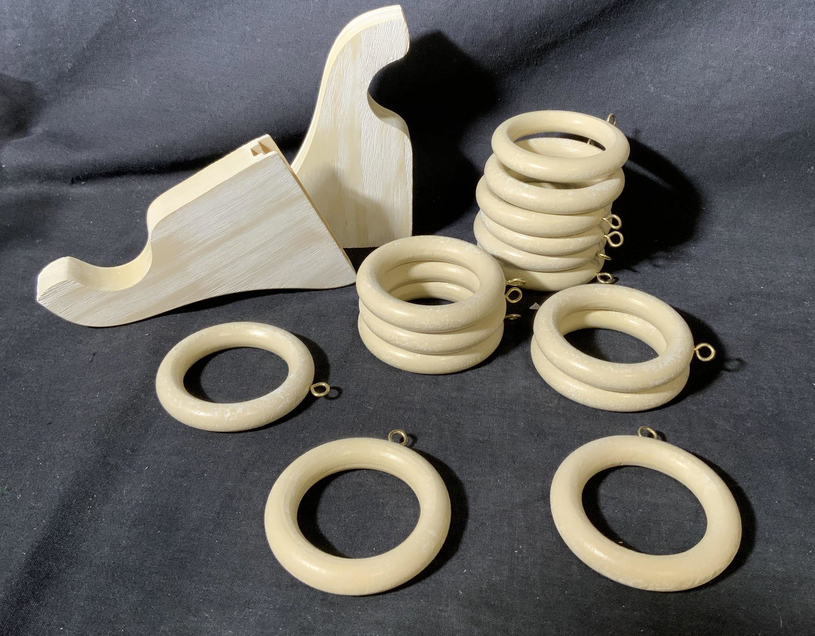 Wood Curtain Rings with matching Wall Rackets: Wood Curtain Rings with matching Wall Rackets, each ring has a diameter of 1 7/8 inches and at 1/2 inches wide, brackets measure 5 1/4 L x 3 3/4 H x 7/8 W, beige colored, surface wear to pieces. Prope