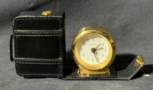 Hampton Miniature Suitcase Clock: Hampton. Miniature Suitcase Clock, face of clock reads ‘Hampton’ and ‘Quarts’, verso of clock reads ‘Made in Hong Kong’, inscriptions of fastening button reads ‘Mark Tigon’, measures 2