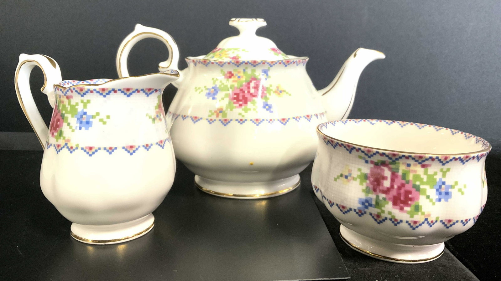 3 ROYAL ALBERT ENGLAND Teapot Creamer & Sugar: Undersides are marked ROYAL ALBERT BONE CHINA ENGLAND. Lot includes 1 Teapot with lid, 1 creamer dish and 1 sugar dish. Each piece has digi floral and leaf detail. Each rim and some edges are gold ton