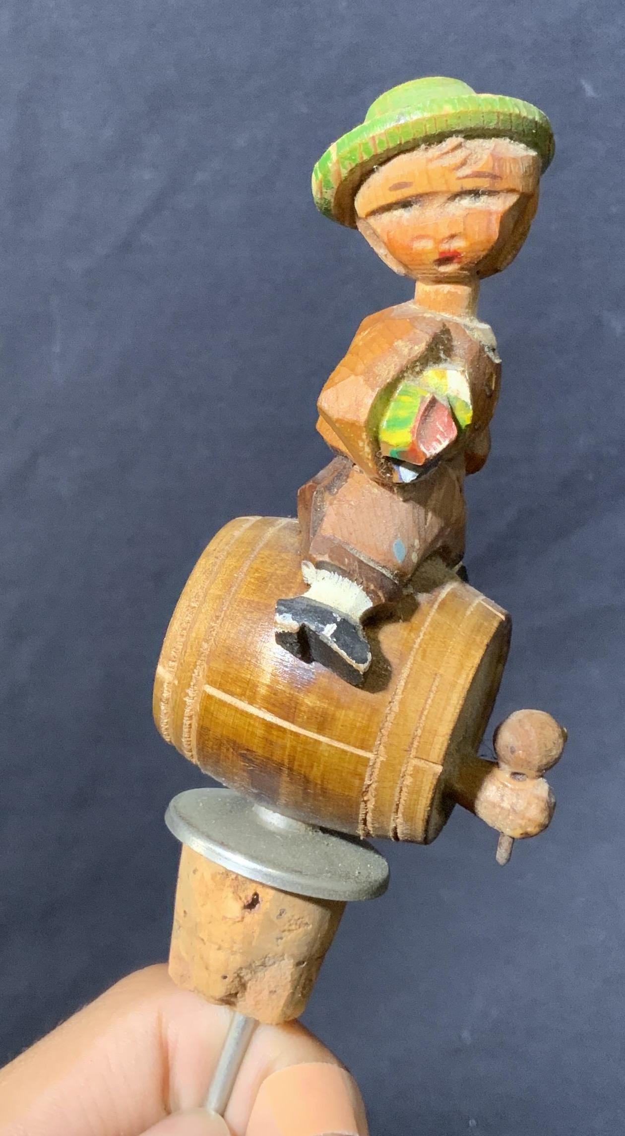 Antique Wood Lederhosen Figurine Bottle Stopper: Antique Wood Lederhosen Figurine Bottle Stopper, Measures 6 in tall, cork and needle measure 2 3/4 h x 1 in diameter, boy is wearing a lederhosen, head is attached to body on a string and moves easily